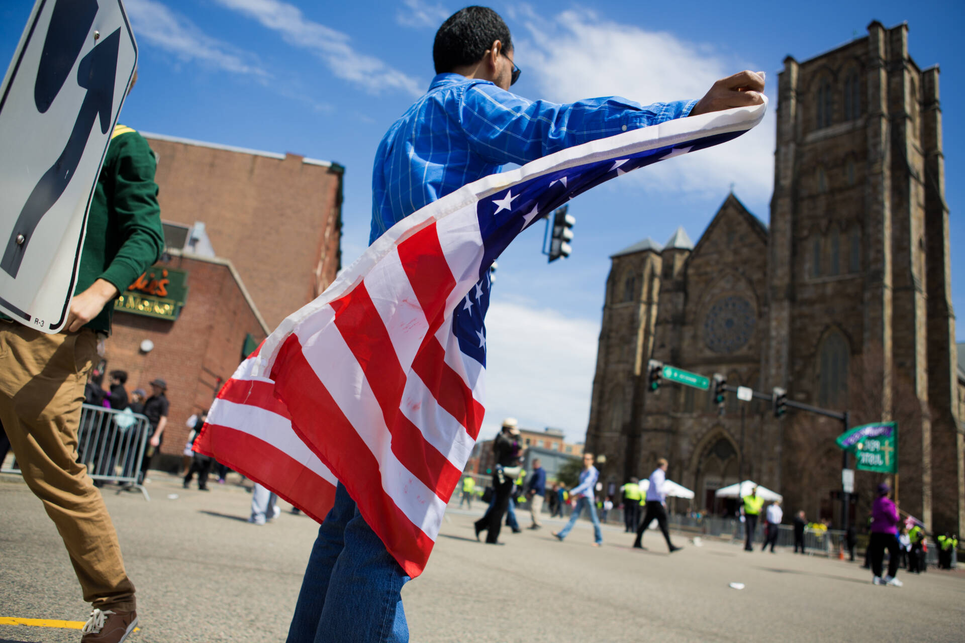 Jose Bricena, of Cambridge, holds an American flag outside the Cathedral of the Holy Cross, where then-President Barack Obama spoke to honor the victims of the Boston Marathon bombings. (Jesse Costa/WBUR)