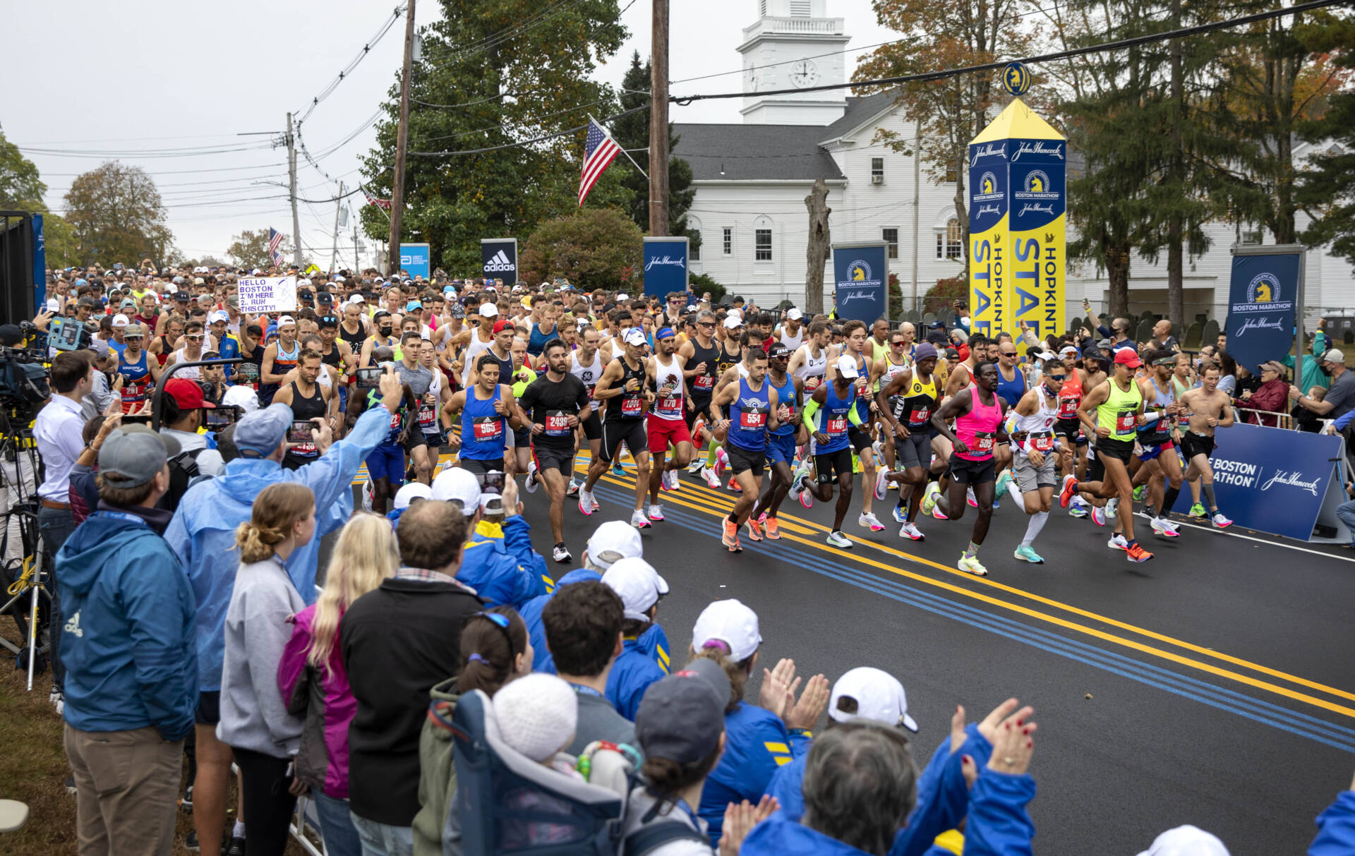 Runners in the rolling start for all participants cross the start line in the 125th Boston Marathon. (Robin Lubbock/WBUR)