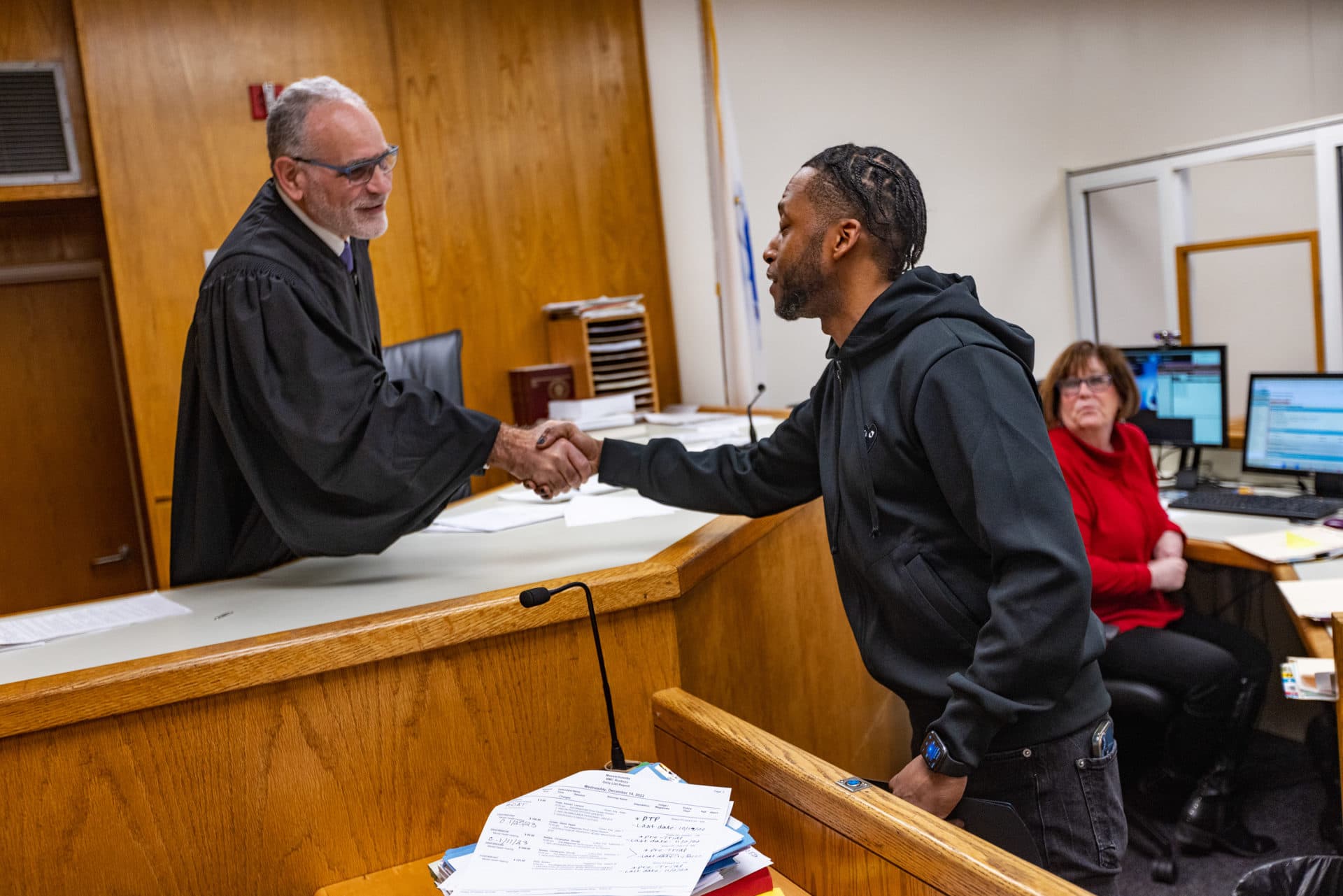 Justice David Weingarten shakes the hand of Kamari Hope, congratulating him upon his completion of the Boston Outpatient Assisted Treatment Program during a hearing at Roxbury District Court. (Jesse Costa/WBUR)