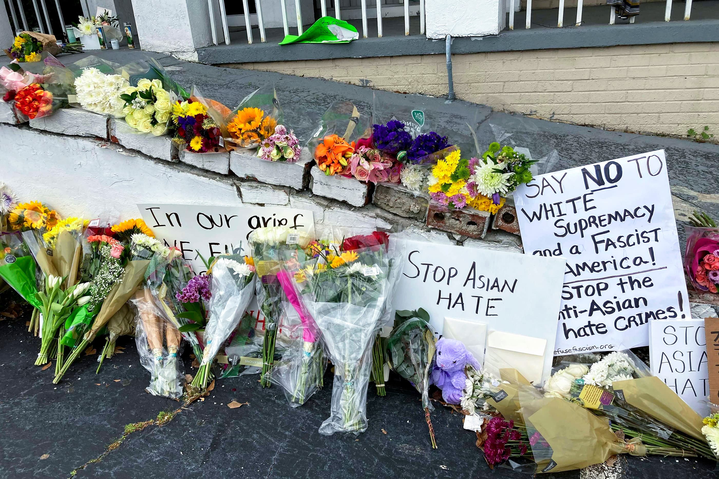 Flowers, candles and signs are displayed at a makeshift memorial in Atlanta, following a shooting. (Candice /AP)