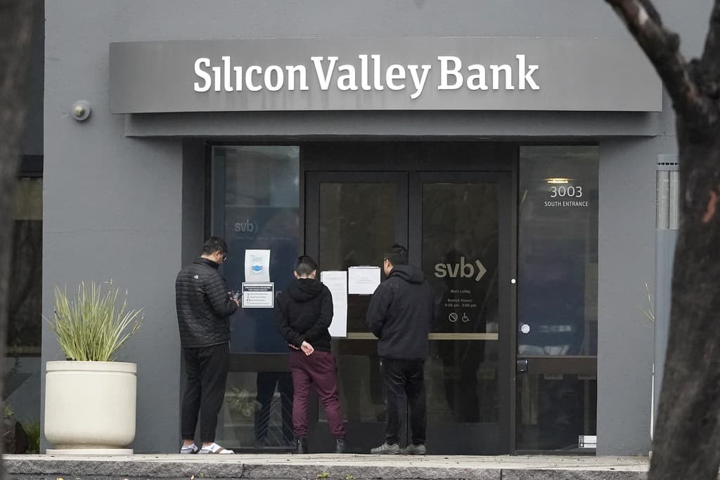 People look at signs posted outside of an entrance to Silicon Valley Bank in Santa Clara, Calif., Friday, March 10, 2023. (Jeff Chiu/AP)