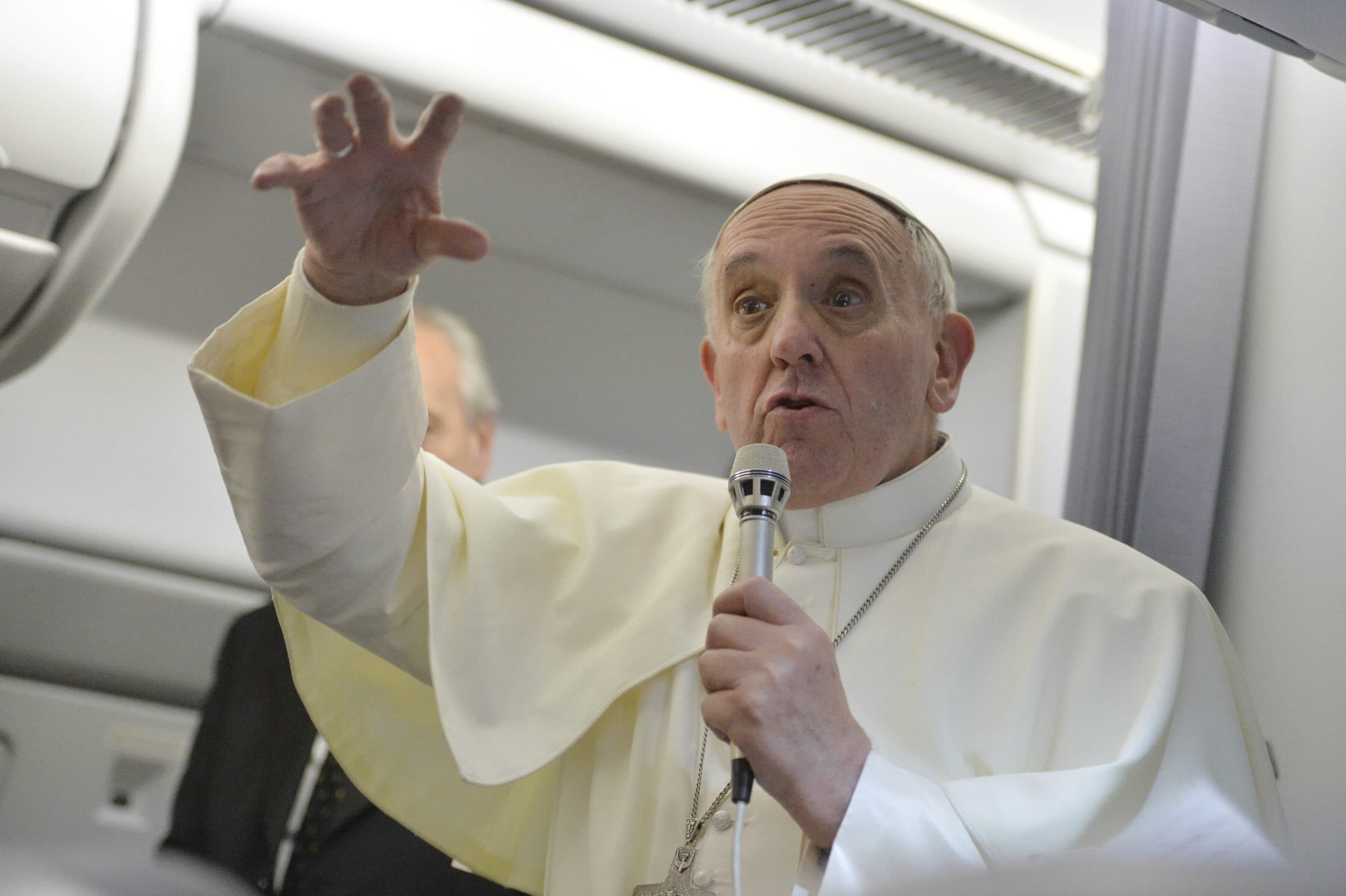 Pope Francis gestures as he answers reporters questions during a news conference. (Luca Zennaro/AP)