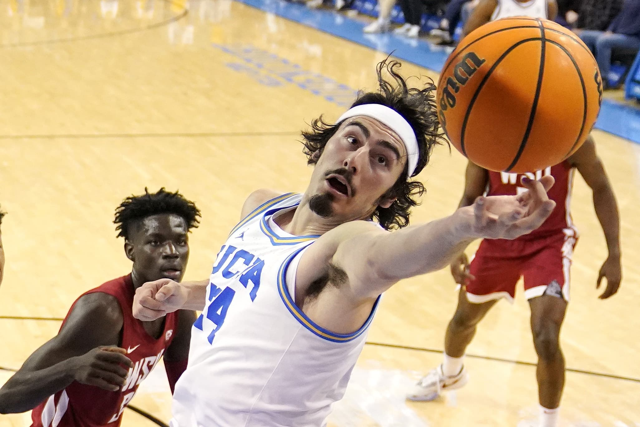 UCLA guard Jaime Jaquez Jr., right, reaches for a rebound as Washington State forward Mouhamed Gueye watches during the first half of an NCAA college basketball game. AP Photo/Mark J. Terrill, File)
