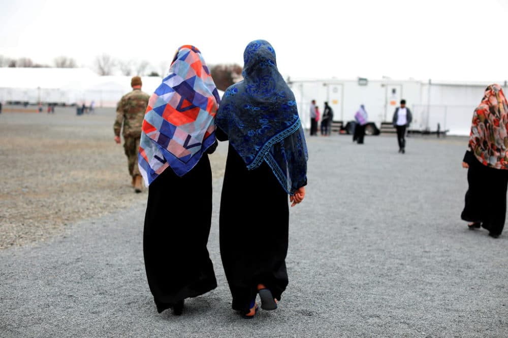 Afghan women refugees and a service member walk inside Liberty Village on December 2, 2021 in Joint Base McGuire-Dix-Lakehurst, New Jersey. (Barbara Davidson-Pool/Getty Images)