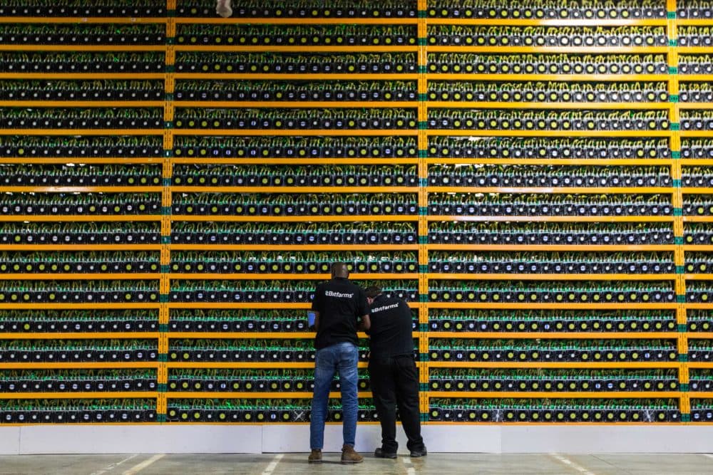 Two technicians inspect bitcon mining at Bitfarms. (Lars Hagberg/AFP via Getty Images)