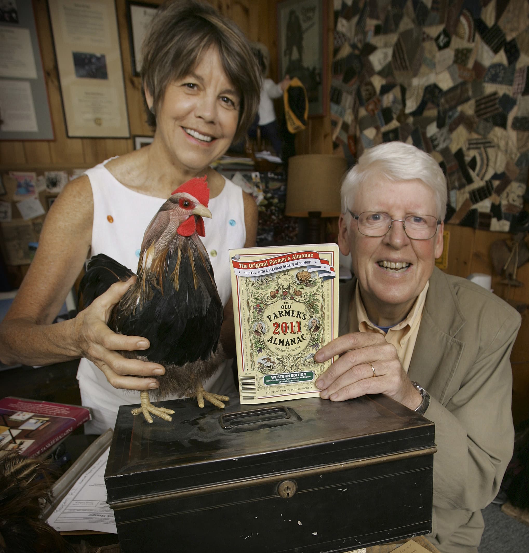 In this Sept. 1, 2010 photo, editor Janice Stillman, left, and editor-in-chief Jud Hale pose in Dublin, N.H., with the 2011 edition of the Old Farmer's Almanac on top of the lock box Hale says has the secret formula to predict weather. (Jim Cole/AP)