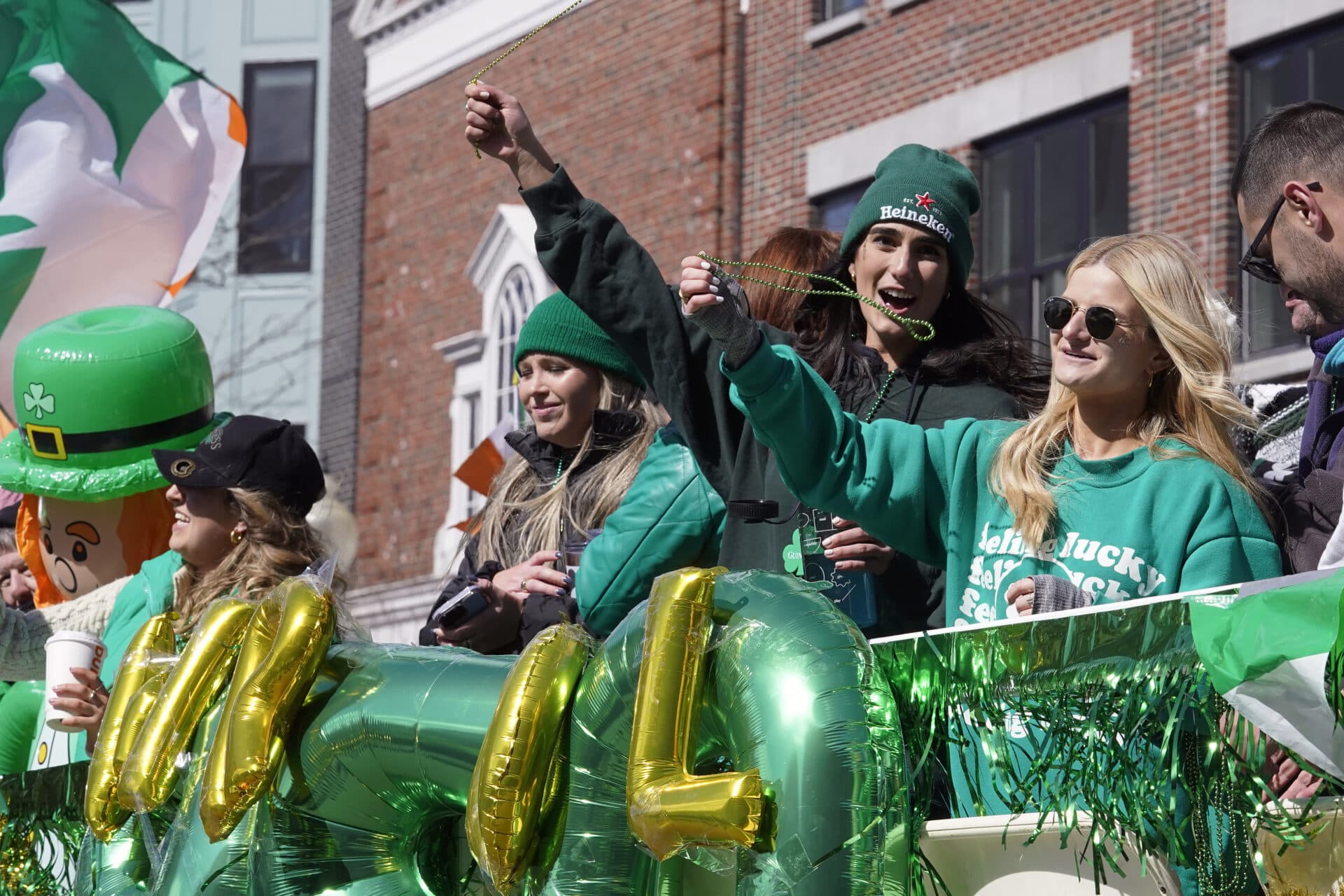 People celebrate while riding on a float during the St. Patrick's Day parade. (Steven Senne/AP)