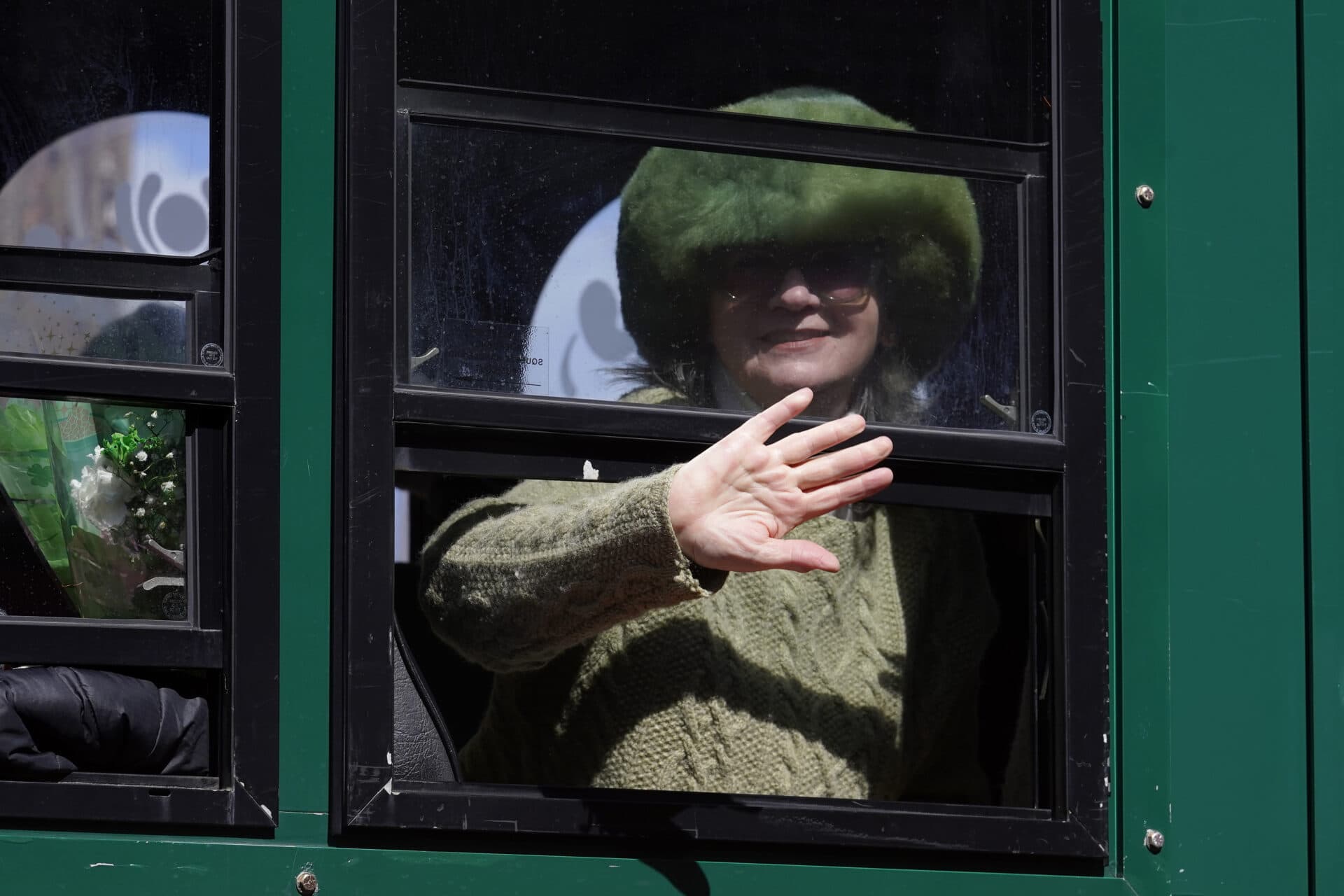 A woman dressed in green waves from a trolly during the annual St. Patrick's Day parade. (Steven Senne/AP)