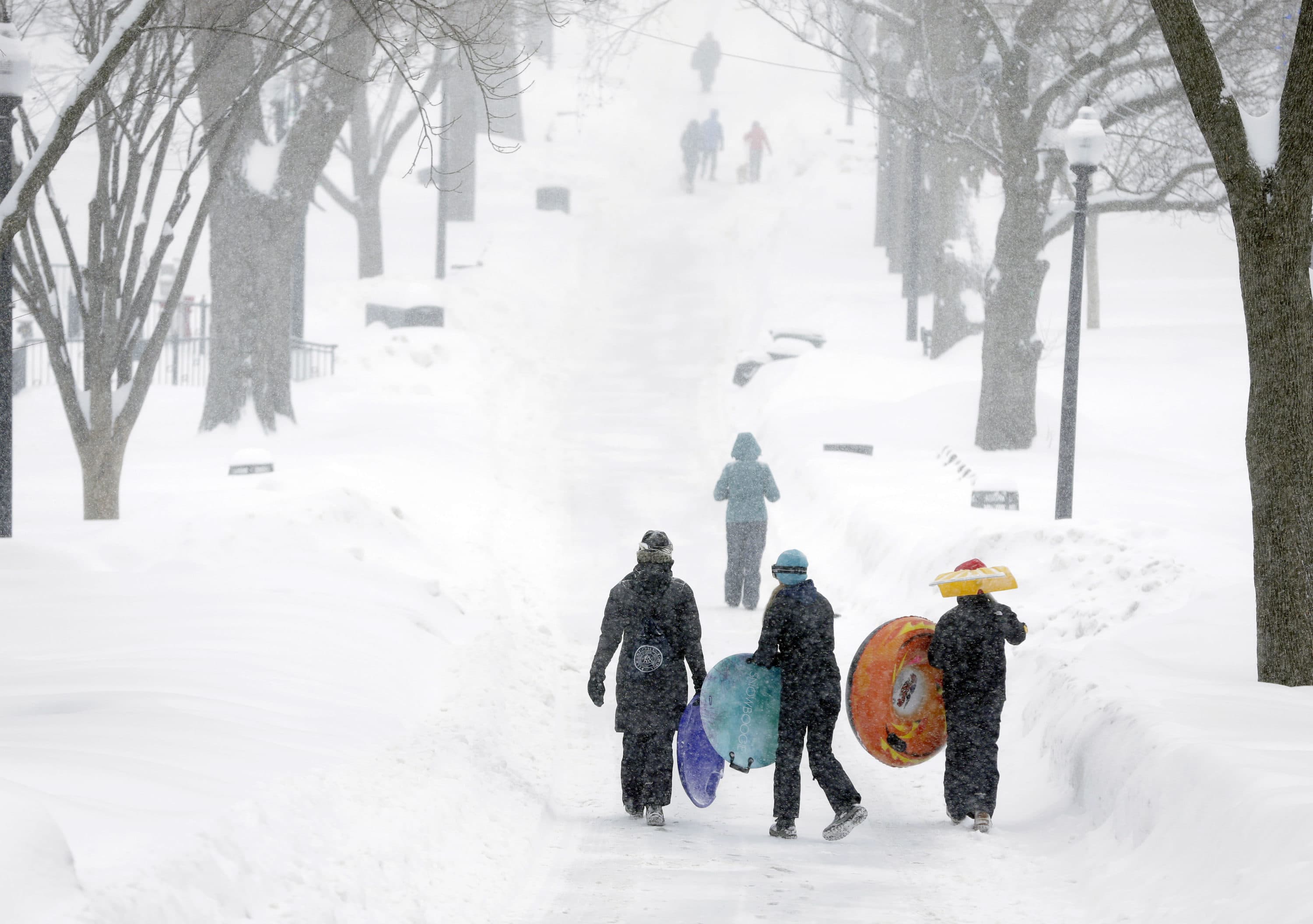 People carry their sleds along a snow-covered walkway in the Boston Common, Feb. 9, 2015, in Boston. (Steven Senne/AP)