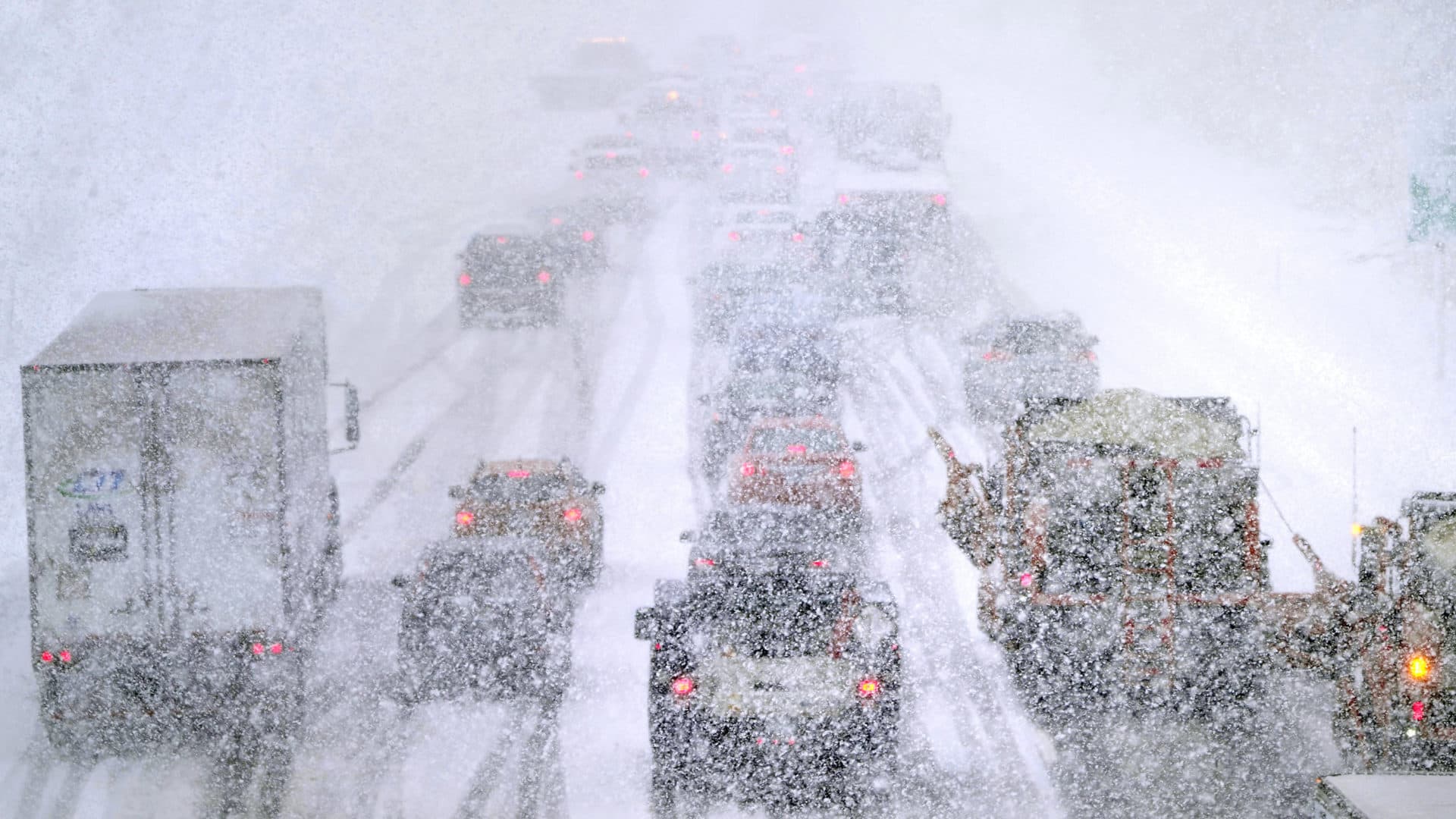 Plows, at right, try to pass nearly stopped traffic, due to weather conditions, on Route 93 South in Londonderry, N.H. (Charles Krupa/AP)