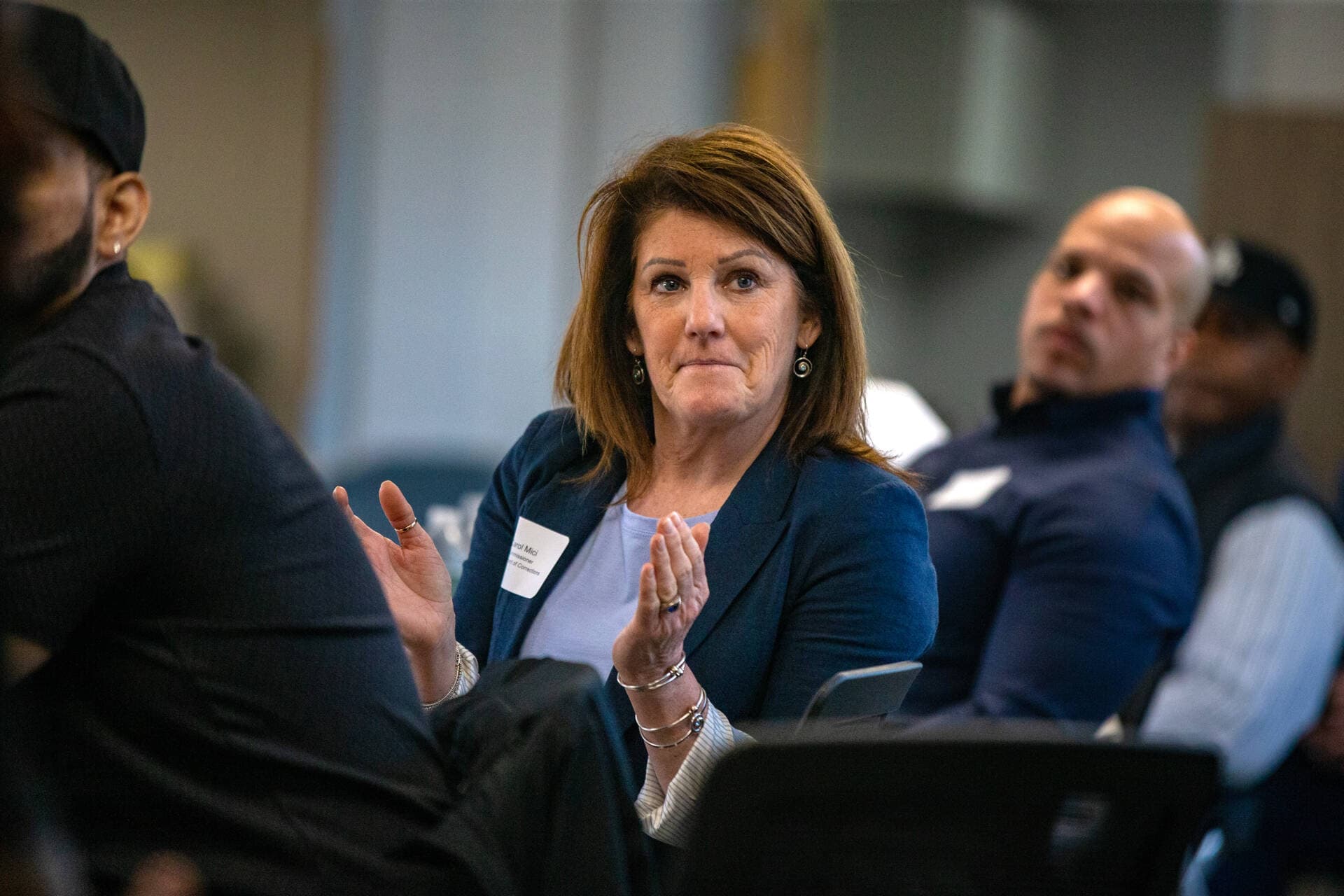 Carol Mici, Commissioner of the Department of Corrections, applauds after hearing a testimonial from one of the former participants of the School of Reentry program during a roundtable discussion at the Boston Pre-Release Center. (Jesse Costa/WBUR)