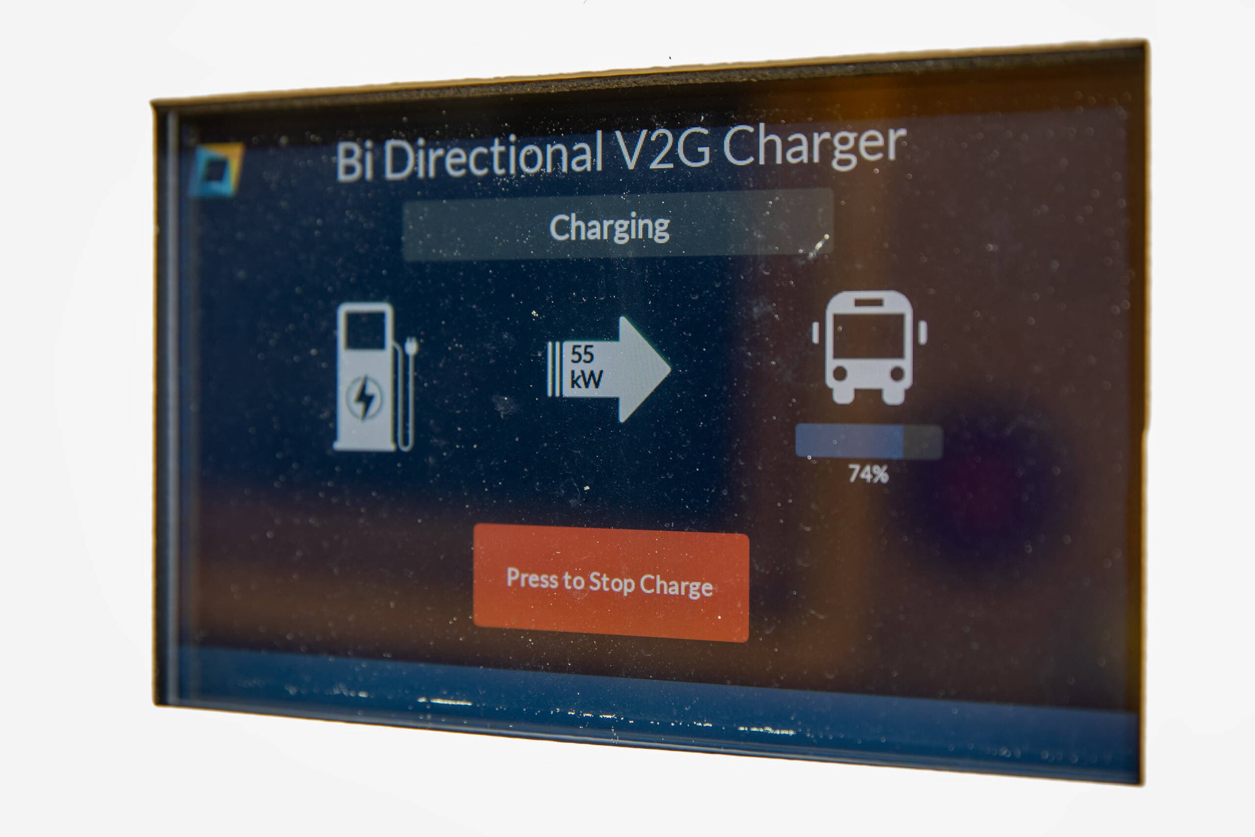 The front panel of an electric school bus charger shows the direction of charge, as well as power and battery level. (Robin Lubbock/WBUR)
