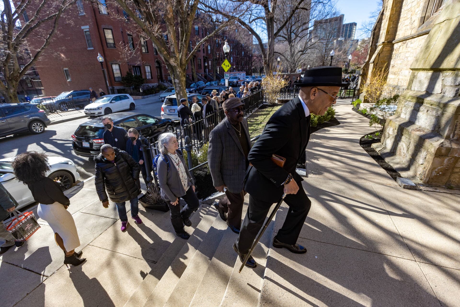 Jose Masso leads a line of people into the Union United Methodist Church in the South End for the public viewing of Mel King. (Jesse Costa/WBUR)
