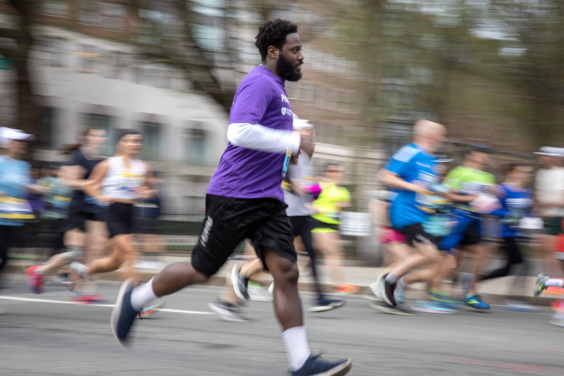 Competitors in the pre-marathon 5K race in Boston dash along Arlington Street. (Robin Lubbock/WBUR)