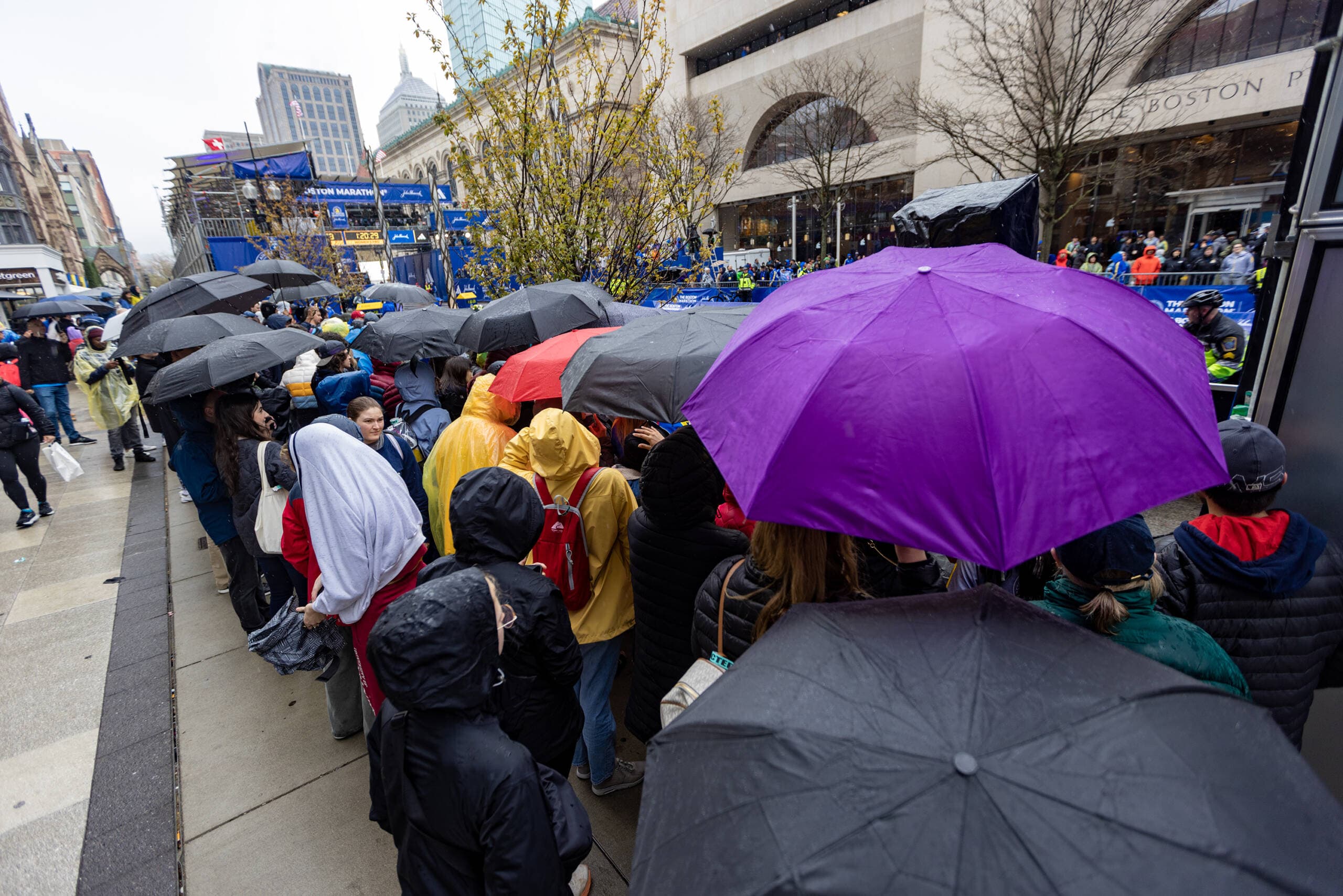 Spectators with umbrellas attempt to stay dry down on the finish line. (Jesse Costa/WBUR)