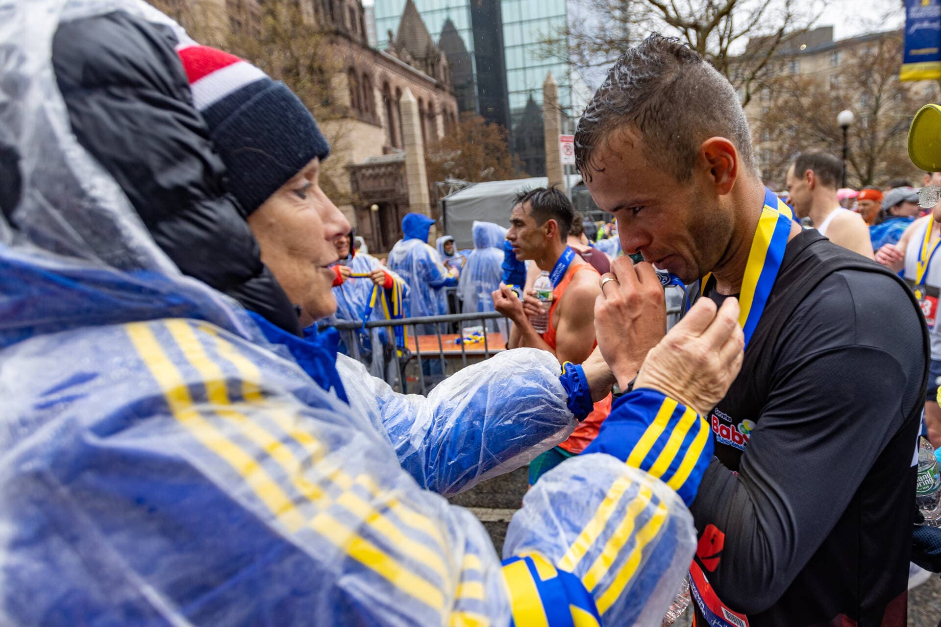 Paulo Dos Santos kisses his Boston Marathon medal. (Jesse Costa/WBUR)