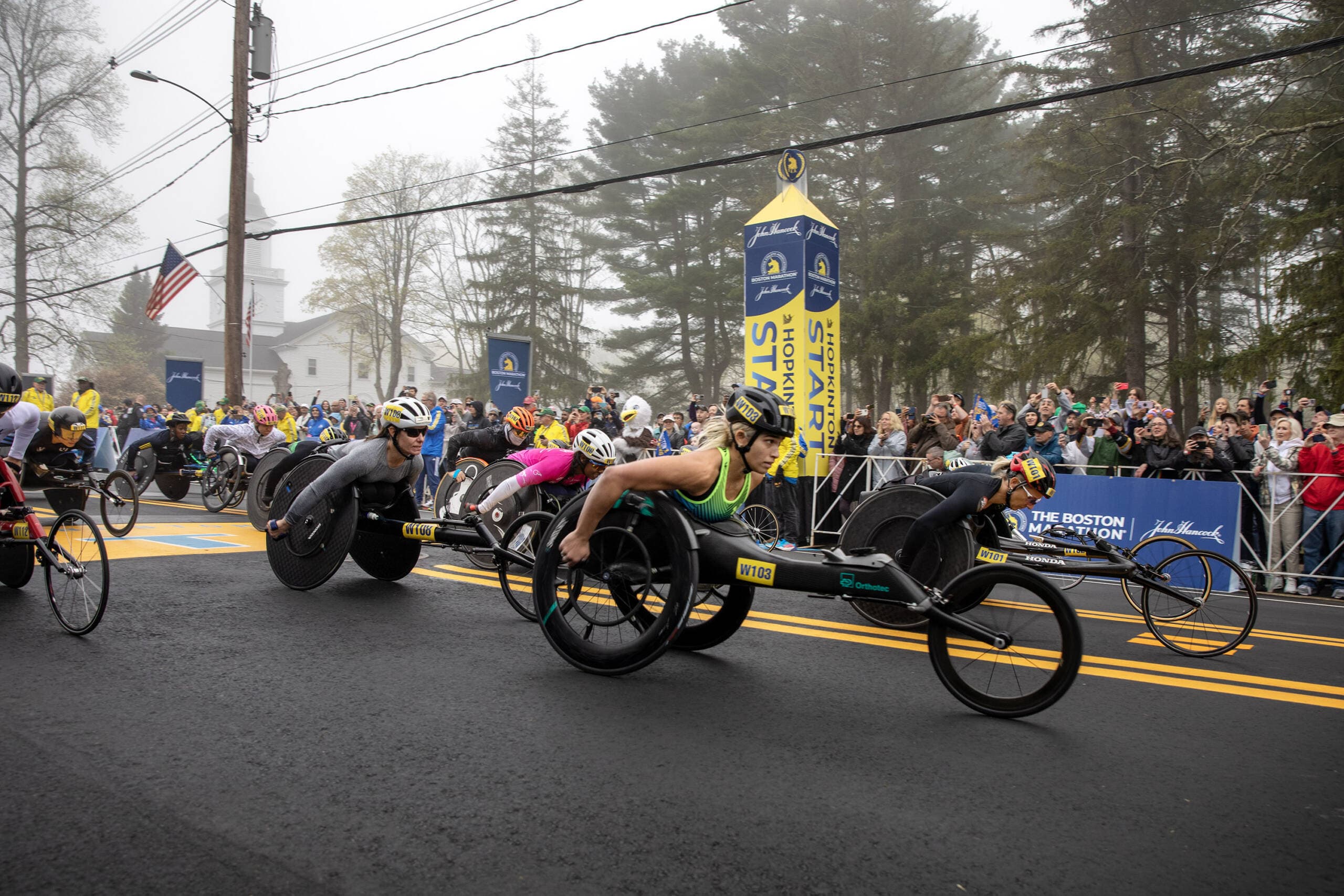 The women's wheelchair division crosses the starting line at the 127th Boston Marathon. (Robin Lubbock/WBUR)