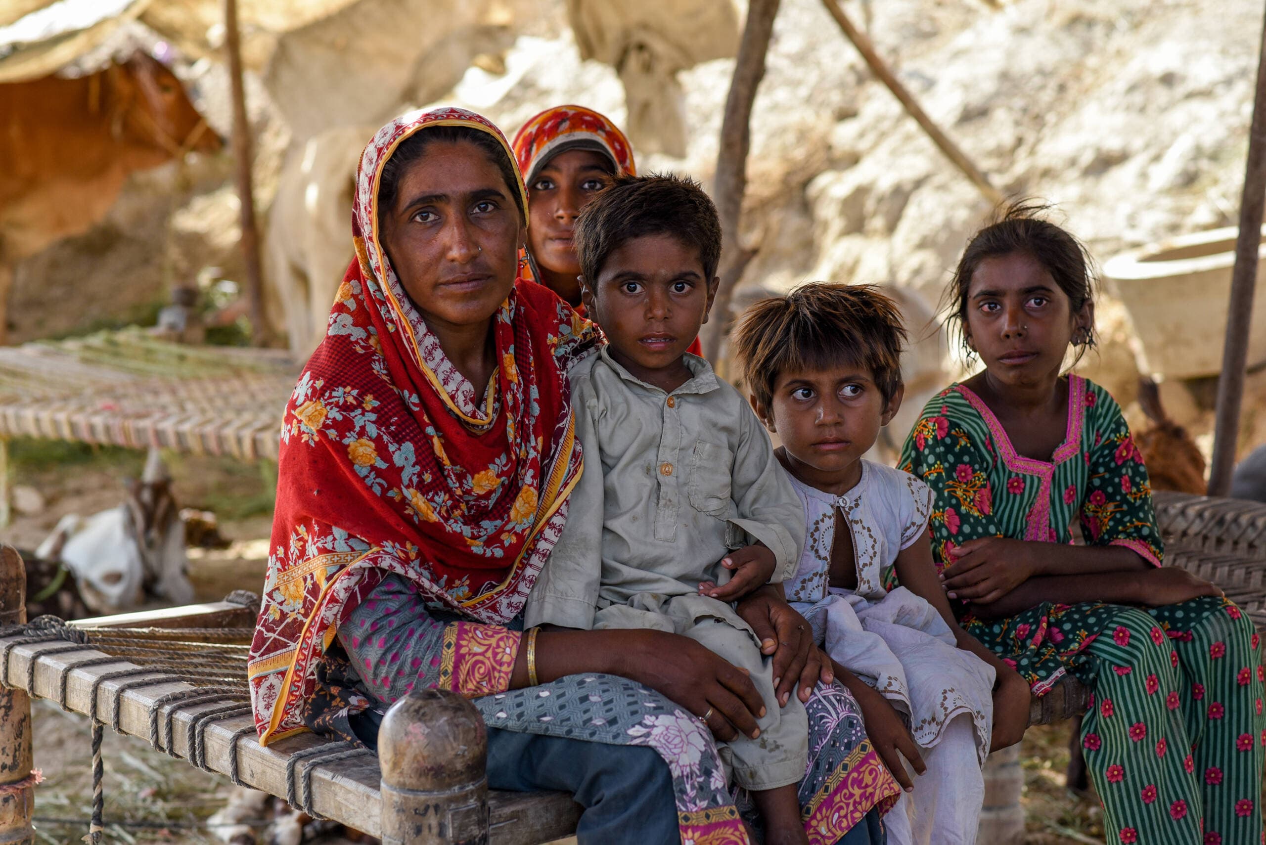 Two sisters and their children in a temporary shelter near their home, which is now under flood water in Sindh, Pakistan. (Saima Javaid for the IRC)