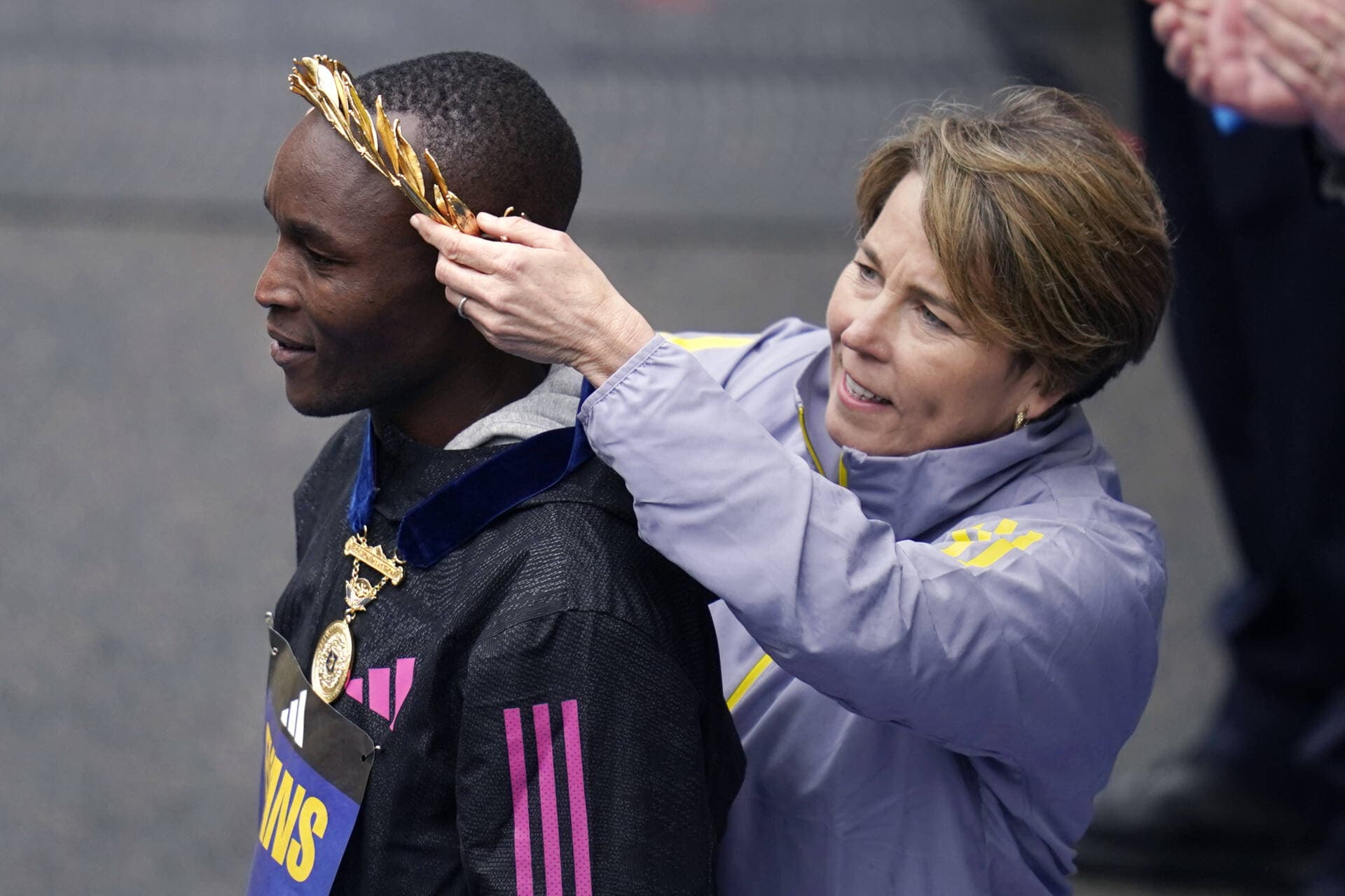 Evans Chebet, of Kenya, stands during the awards ceremony after winning men's division of the Boston Marathon, Monday, April 17, 2023, in Boston. At right is Mass. Gov. Maura Healey. (Charles Krupa/AP)