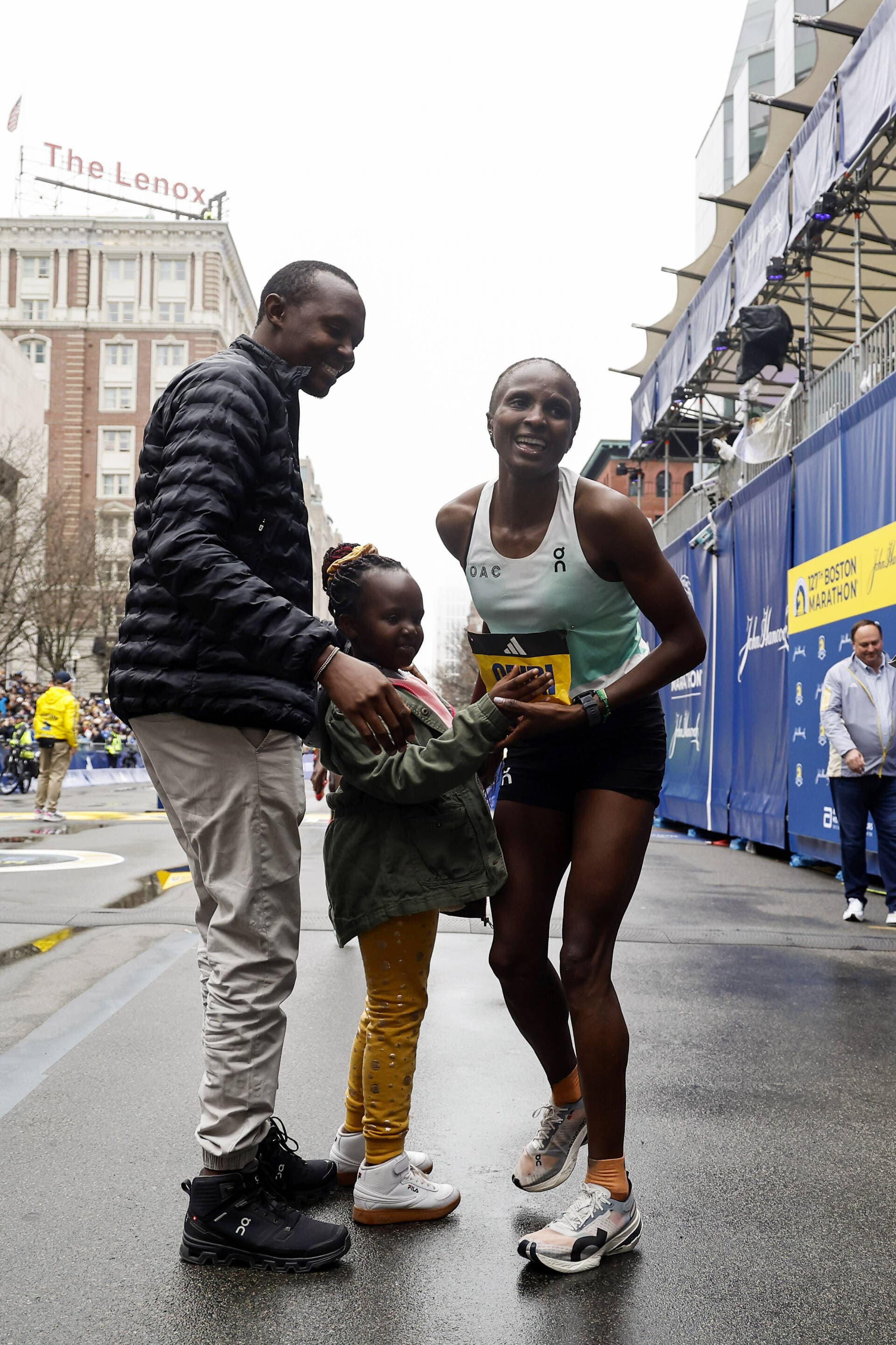 Hellen Obiri of Kenya is greeted by her husband Tom Nyaundi and her daughter Tania after winning the women's division of the 127th Boston Marathon, Monday, April 17, 2023, in Boston. (Winslow Townson/AP)