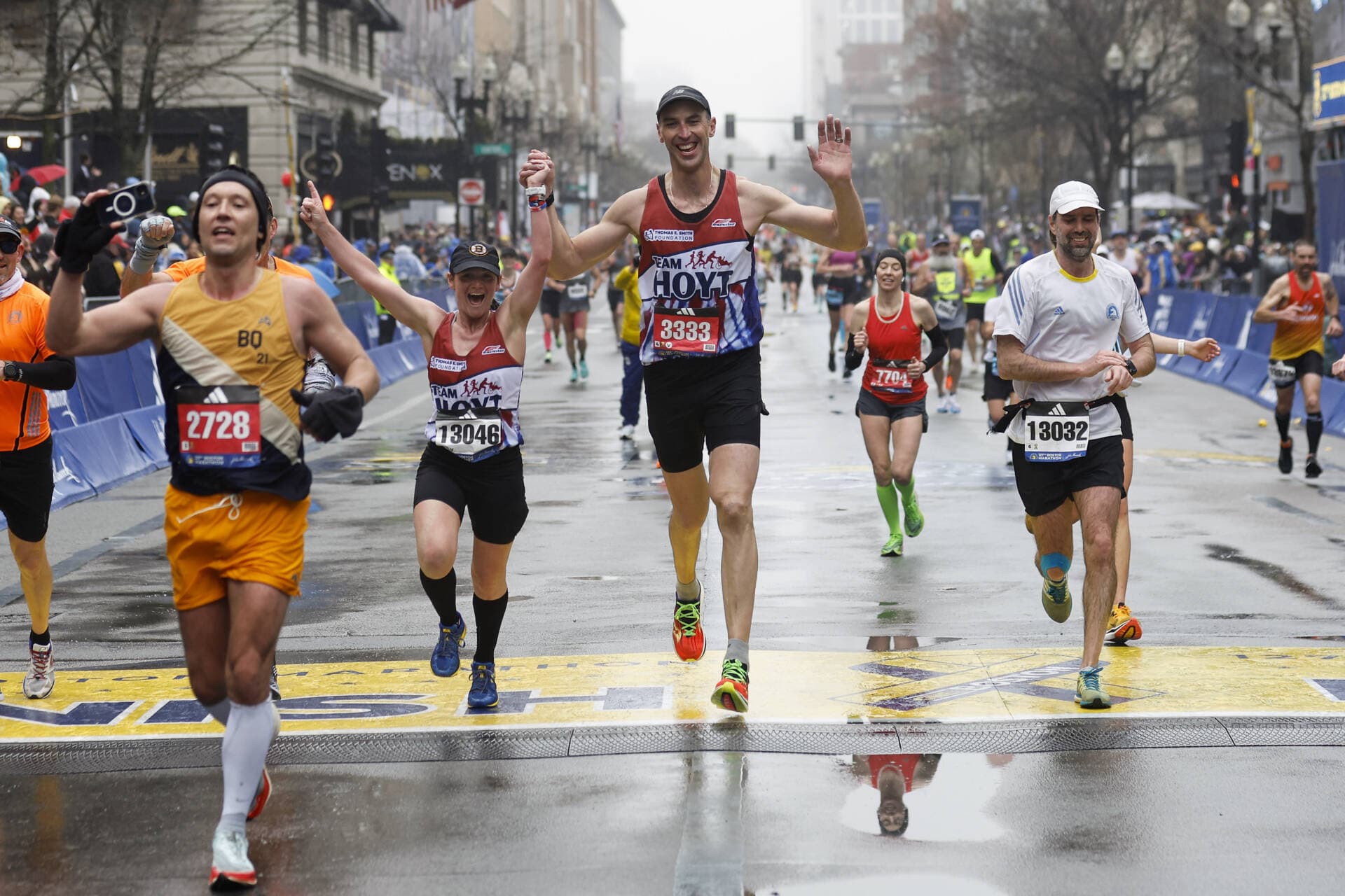 Former Boston Bruins captain Zdeno Chara, center, crosses the finish line holding hands with Becca Pizzi during the 127th Boston Marathon Monday, April 17, 2023, in Boston. (Winslow Townson/AP)