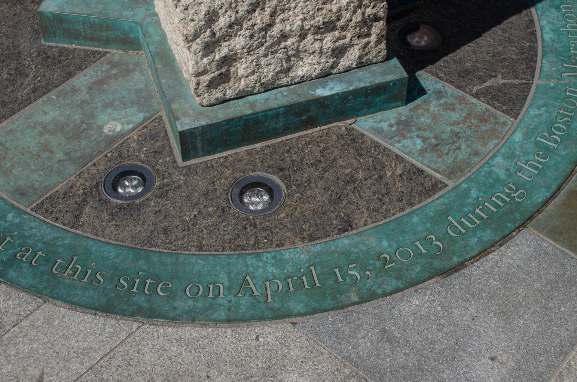 Engraving of the date of the bombings, April 15, 2013, at the Boston Marathon Survivor Memorial. (Sharon Brody/WBUR)