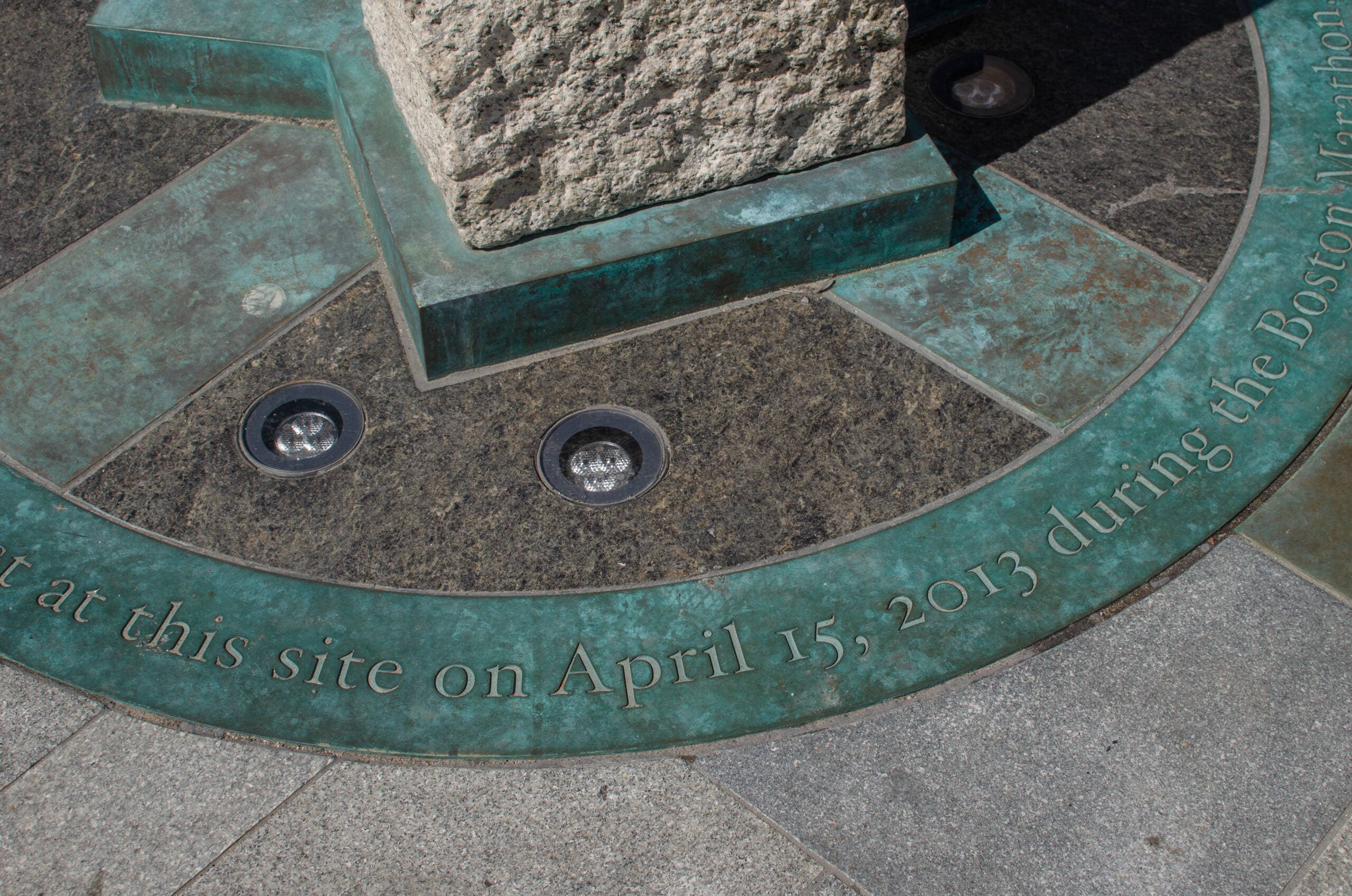 Engraving of the date of the bombings, April 15, 2013, at the Boston Marathon Survivor Memorial. (Sharon Brody/WBUR)