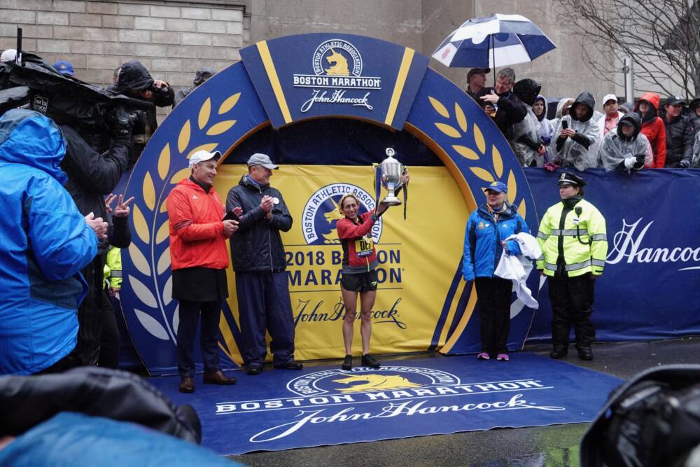 Des Linden holds up the Boston Marathon trophy. (Courtesy of Carrie Cox)