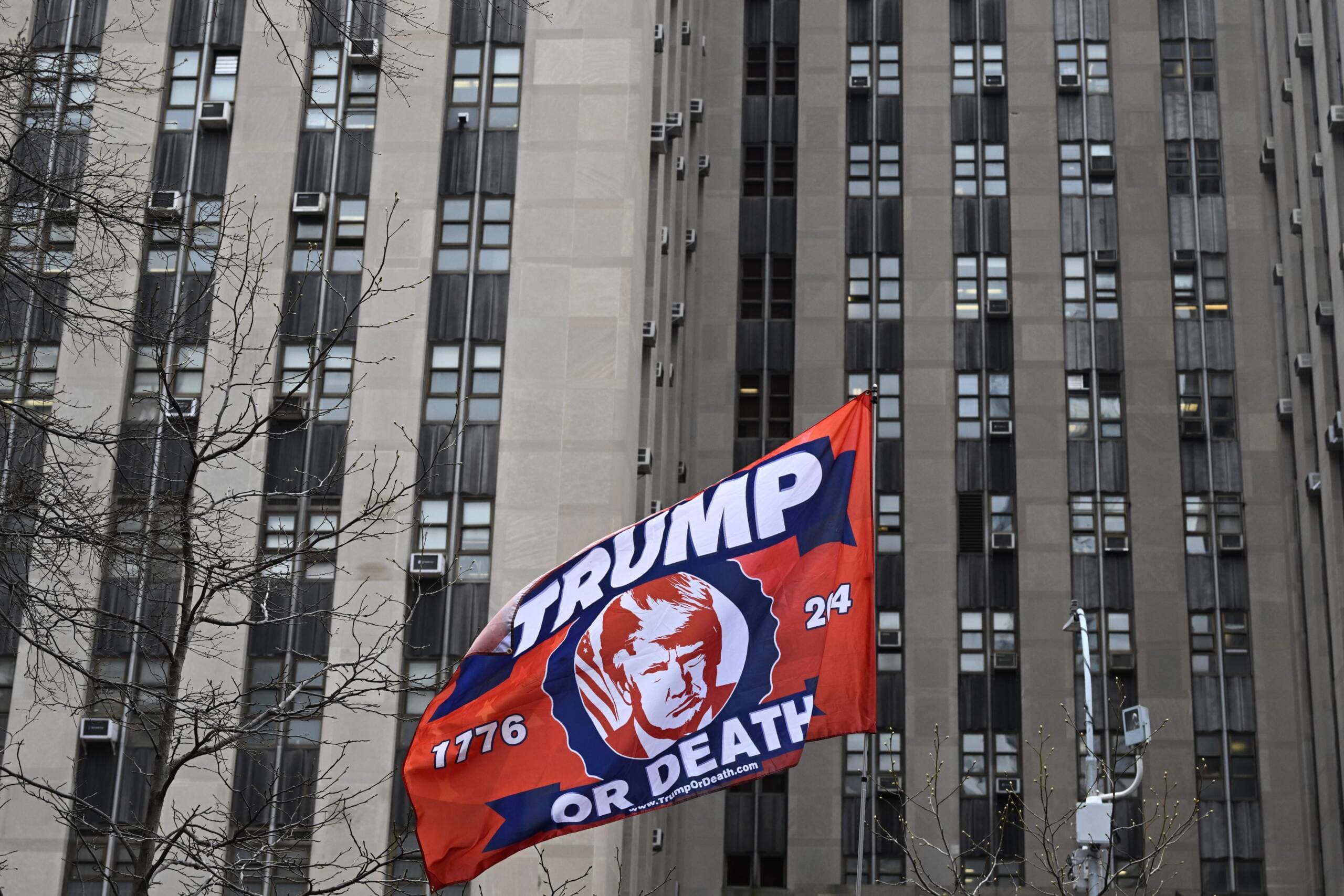 A supporter of former President Donald Trump holds a flag outside the Manhattan District Attorney's office in New York City on April April 4, 2023. (Andrew Caballero-Reynolds)