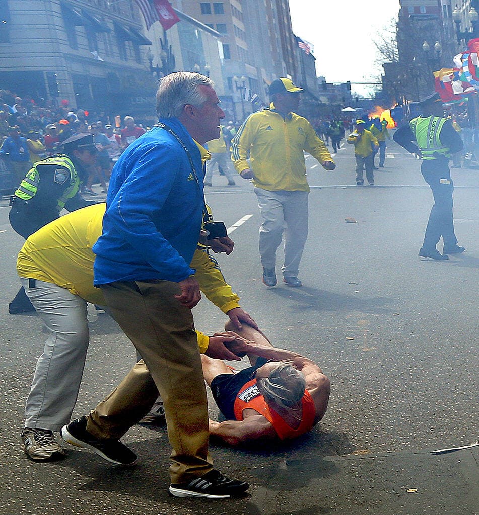 A second explosion goes off (rear) as 78-year-old US marathon runner Bill Iffrig was blown to the ground by the first explosion near the finish line of the 117th Boston Marathon. April 15, 2013, Boston. (John Tlumacki/The Boston Globe via Getty Images)