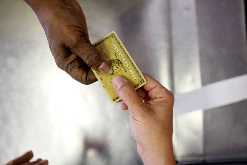 Yera Dominguez receives a credit card from a customer. (Joe Raedle/Getty Images)