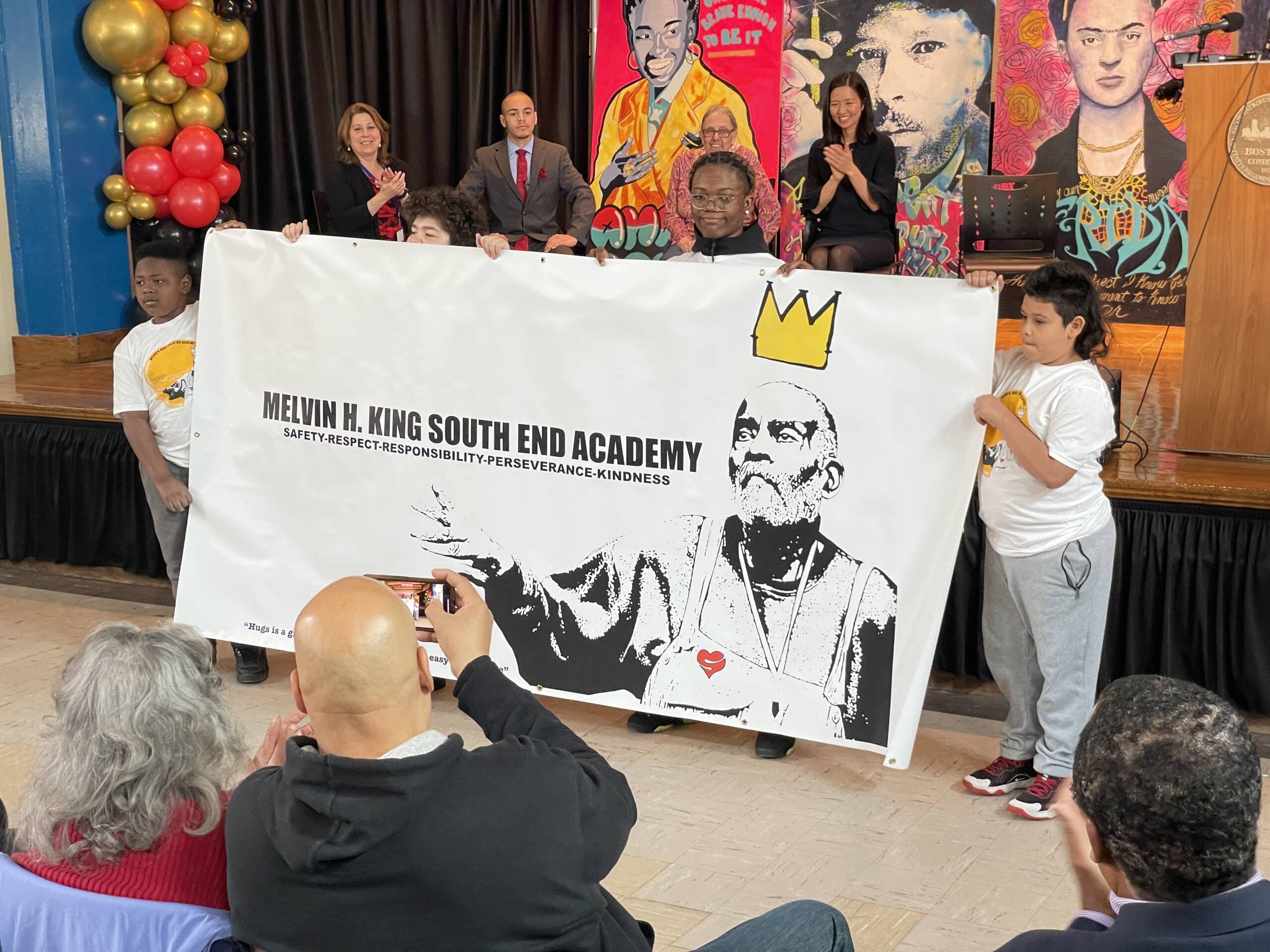 Students at the Mel King South End Academy unveil the school's new name. (Max Larkin/WBUR)