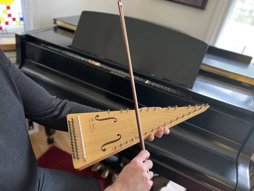 Eric Shimelonis plays the bowed psaltery: a hand-held triangular-shaped melody instrument played with a bow. (Courtesy of Rebecca Sheir)