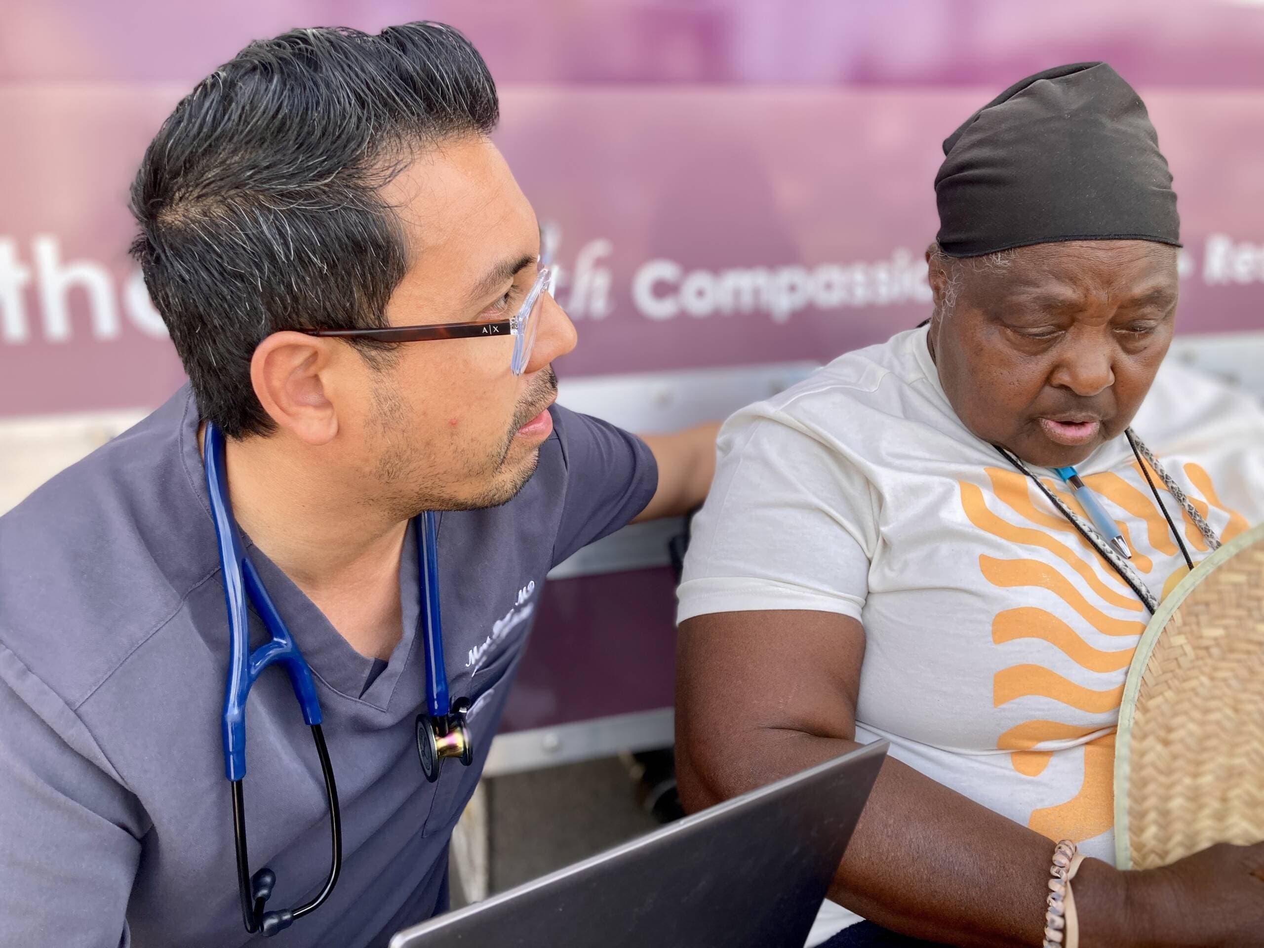 Dr. Mark Bueno discusses lab results with a patient who has come to his mobile medical unit in Phoenix, Ariz. (Peter O'Dowd/Here &amp; Now)