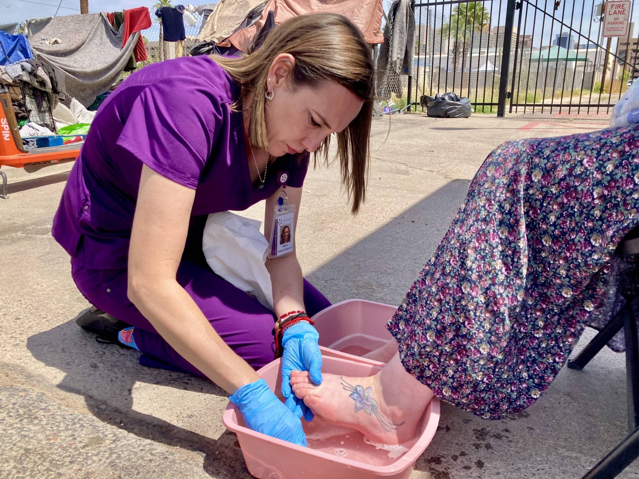 Circle the City Medical Coordinator Monica Rico washes the feet of a woman who has been living in a Phoenix homeless encampment since last year. (Peter O'Dowd/Here &amp; Now)