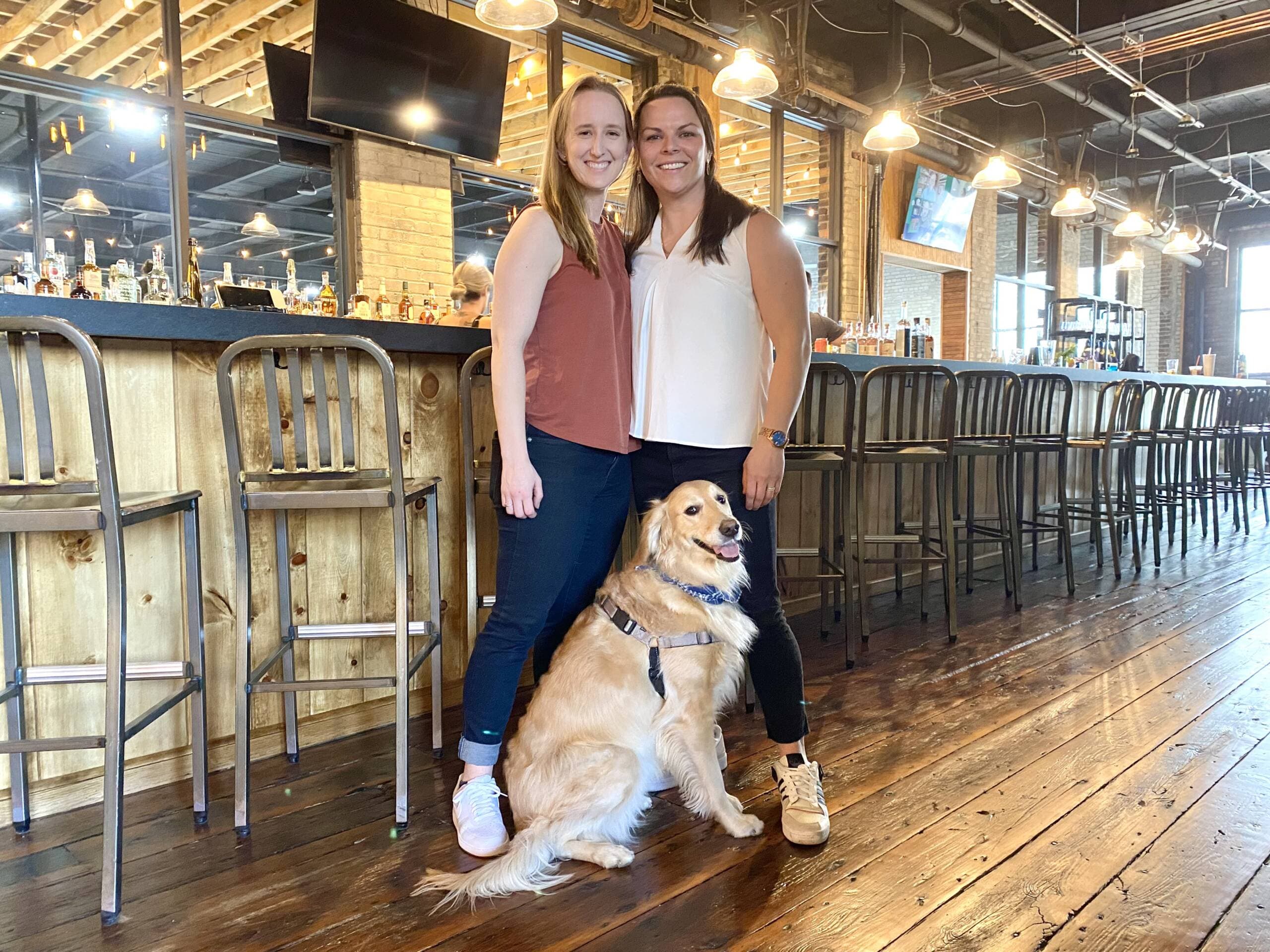 Co-founders Emily Gusse (left) and Tess Kohanski (right) with their golden retriever Nora. (Andrea Shea/WBUR)