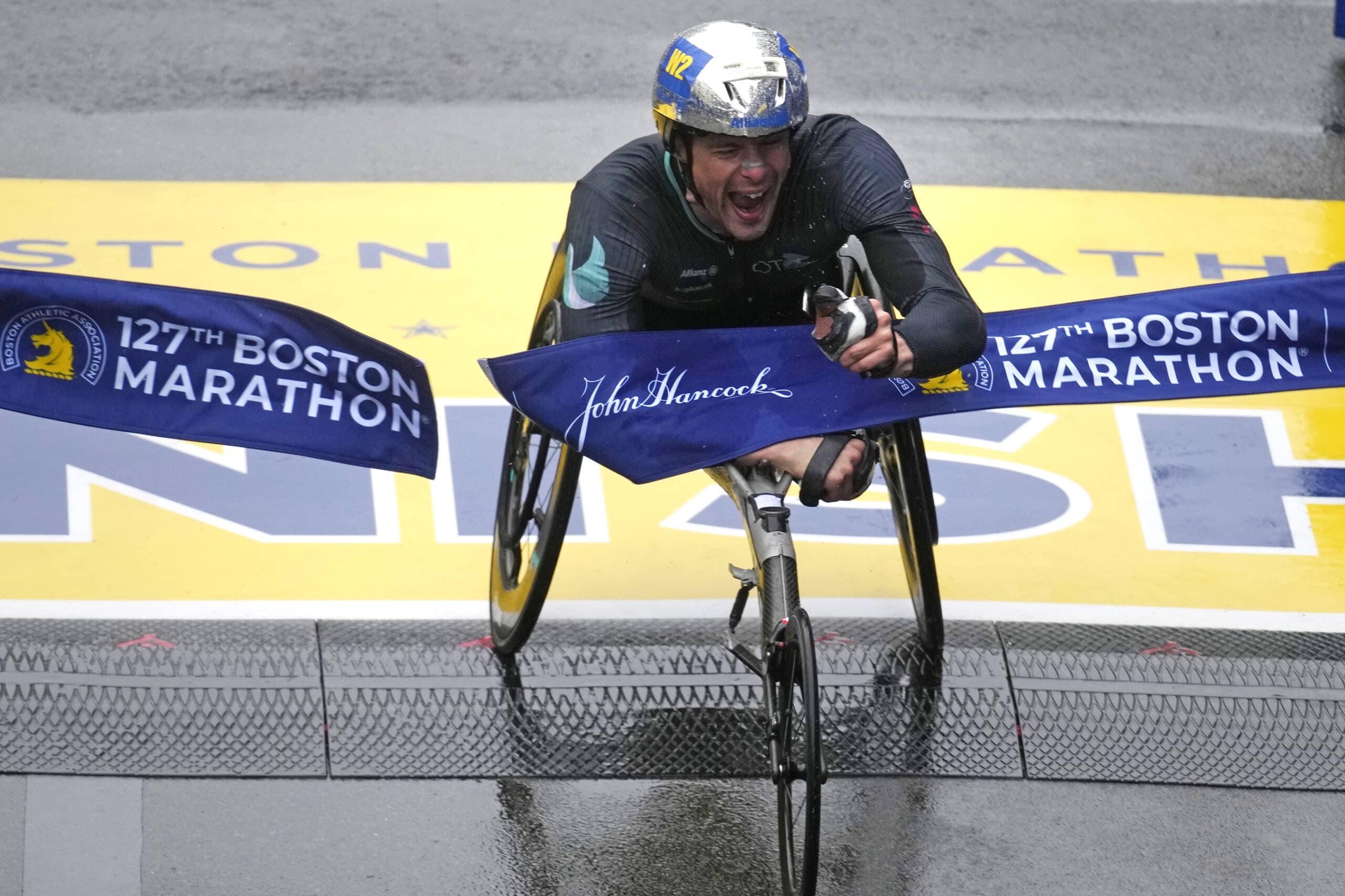 Marcel Hug, of Switzerland, breaks the tape to win the men's wheelchair division of the Boston Marathon in Boston. (Charles Krupa/AP)