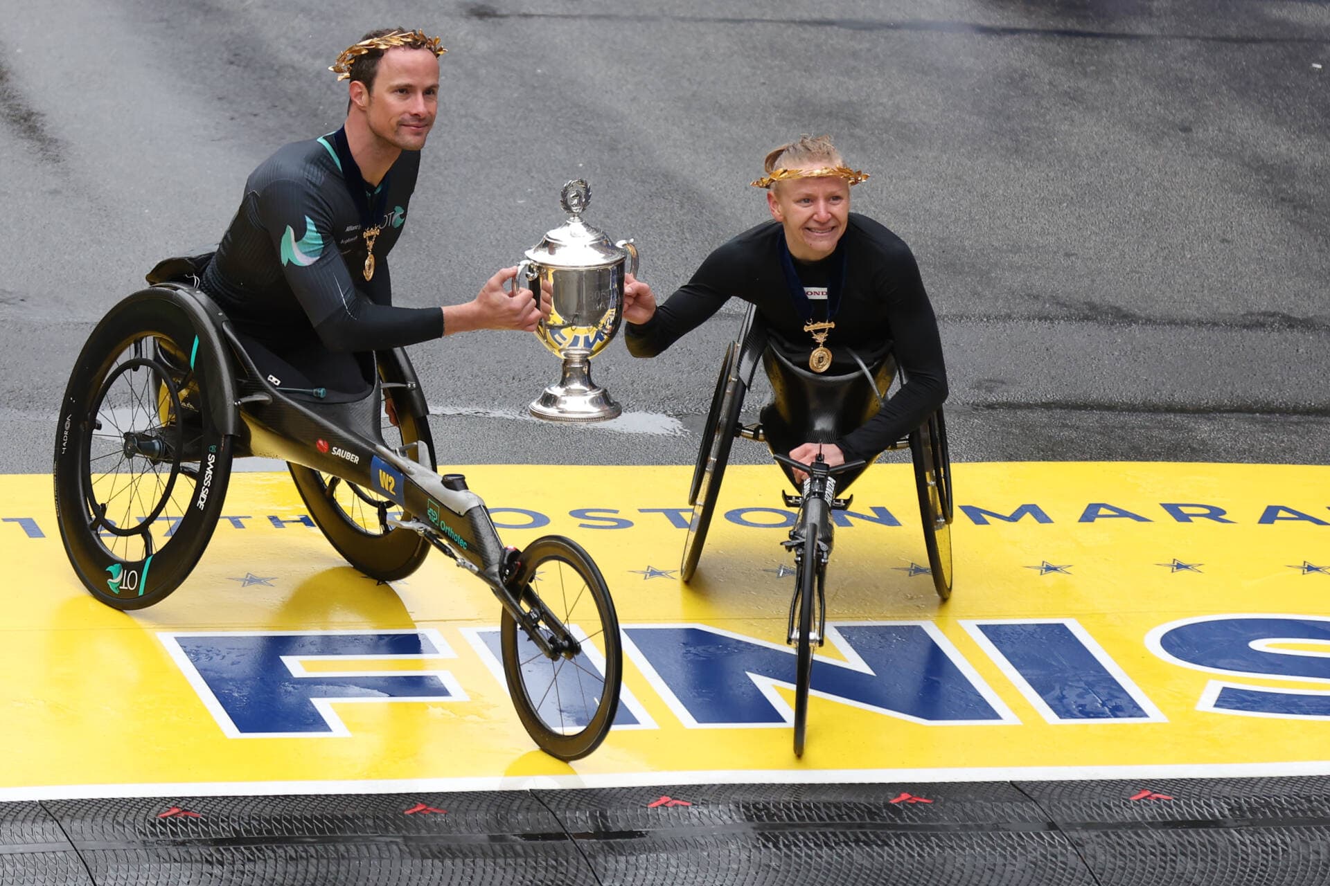 Marcel Hug of Switzerland, left, and Susannah Scaroni of the United States pose with the trophy after winning the professional Men's Wheelchair Division and professional Women's Wheelchair Division respectively during the 127th Boston Marathon on April 17 in Boston. (Omar Rawlings/Getty Images)