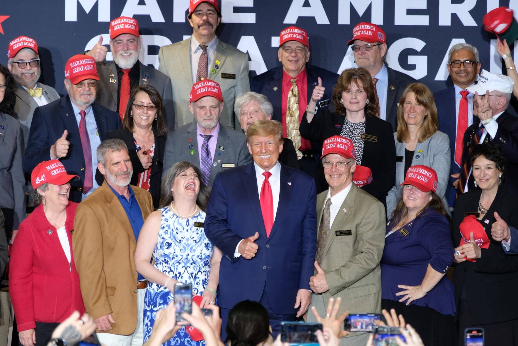 Former President Donald Trump poses with supporters during a rally Thursday in Manchester. (Todd Bookman/NHPR)
