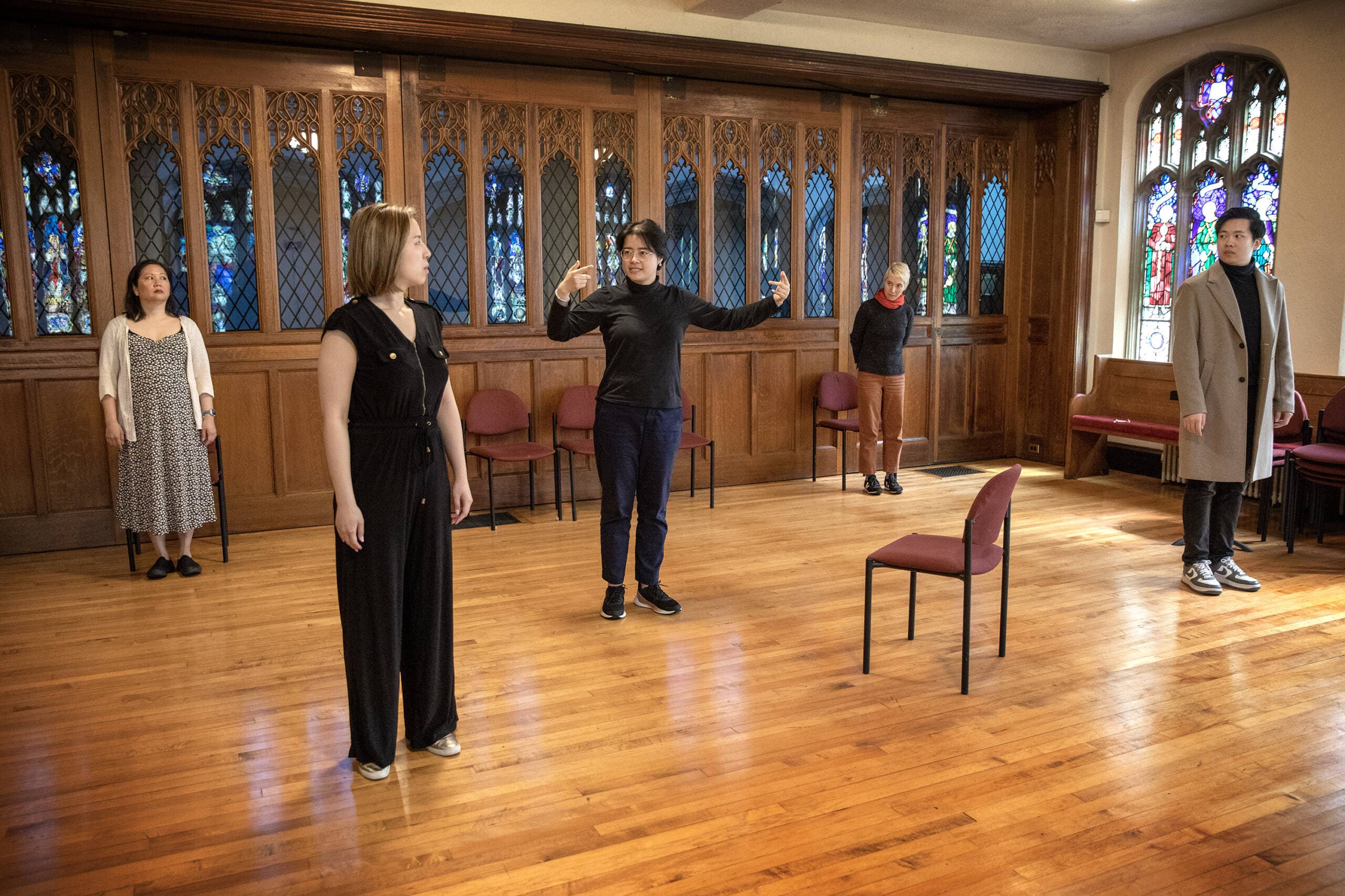 Director Mo Zhou and the cast of Guerilla Opera's production of "HER | alive.un.dead" during rehearsal at Trinity Parish in Newton. (Robin Lubbock/WBUR)