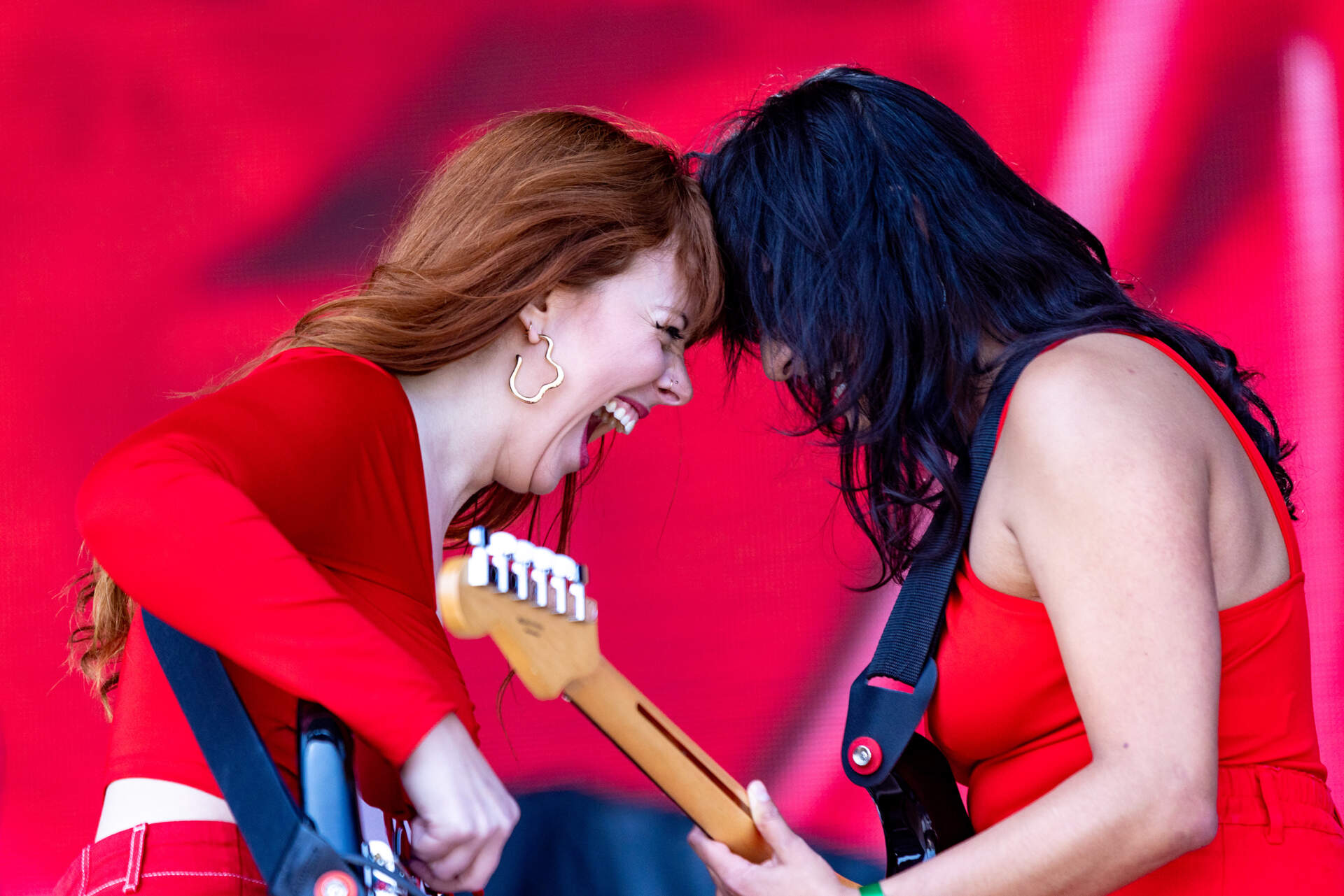 Lead singer and bassist Hollye Bynum, left, and guitarist Jillian Karande bump heads during their set at Boston Calling. (Jesse Costa/WBUR)