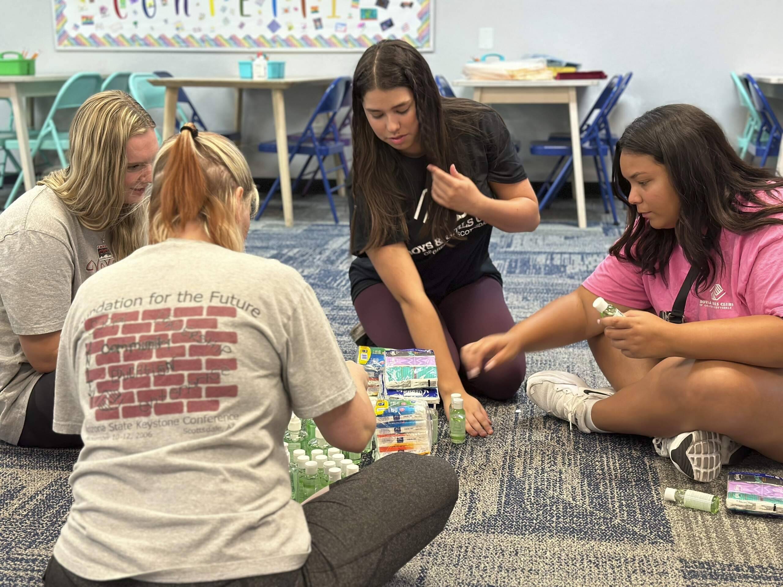 Addison Beer, 17, second from right, and Jaylin Wilson, 18, right, prepares for summer campers arriving next week at the Virginia G. Piper branch of the Boys &amp; Girls Club where she works, Thursday, May, 25, 2023 in Scottsdale, Ariz. With the job market the tightest in half a century, younger workers are playing a critical role in kicking off the summer tourism season this Memorial Day weekend. (Alina Hartounian/AP)