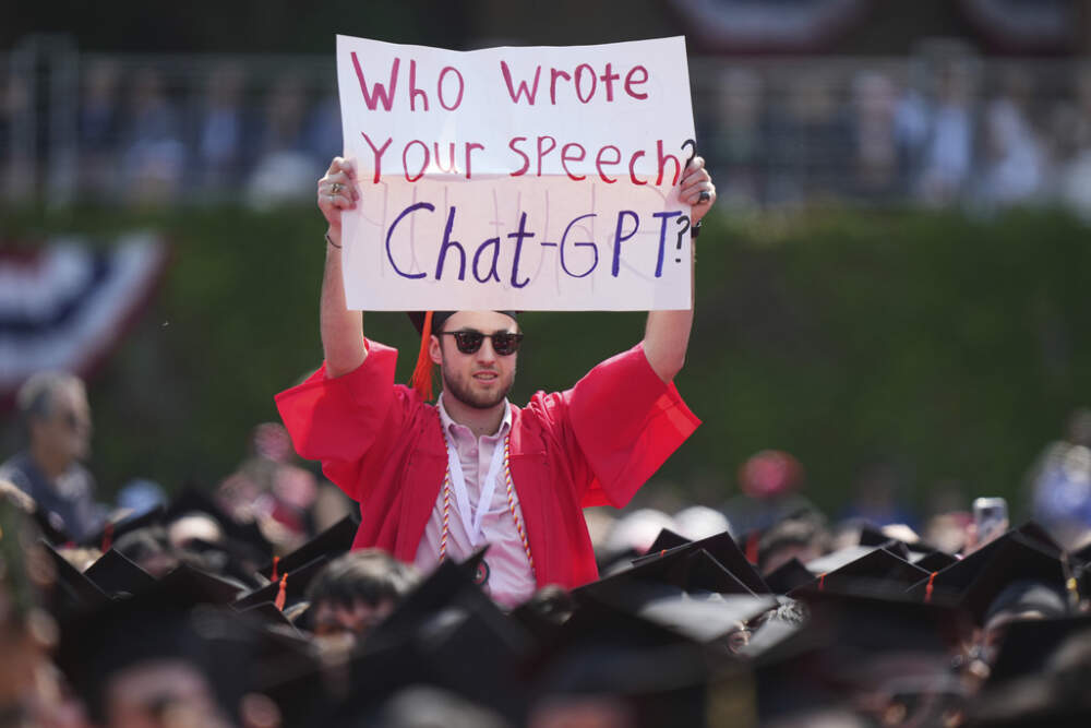 A BU graduate holds a sign that reads, &quot;Who wrote your speech? ChatGPT?&quot; during the commencement address of David Zaslav, president and CEO of Warner Bros. Discovery. (Steven Senne/AP)