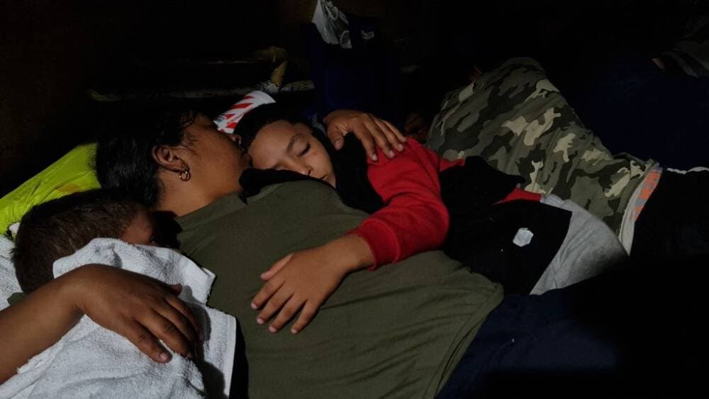 Dasling Sanchez, 28, holds her sleeping sons as they rest next to a gas station in downtown Brownsville, Texas, on May 6, 2023. (Photo by Moisés Avila / AFP via Getty Images)