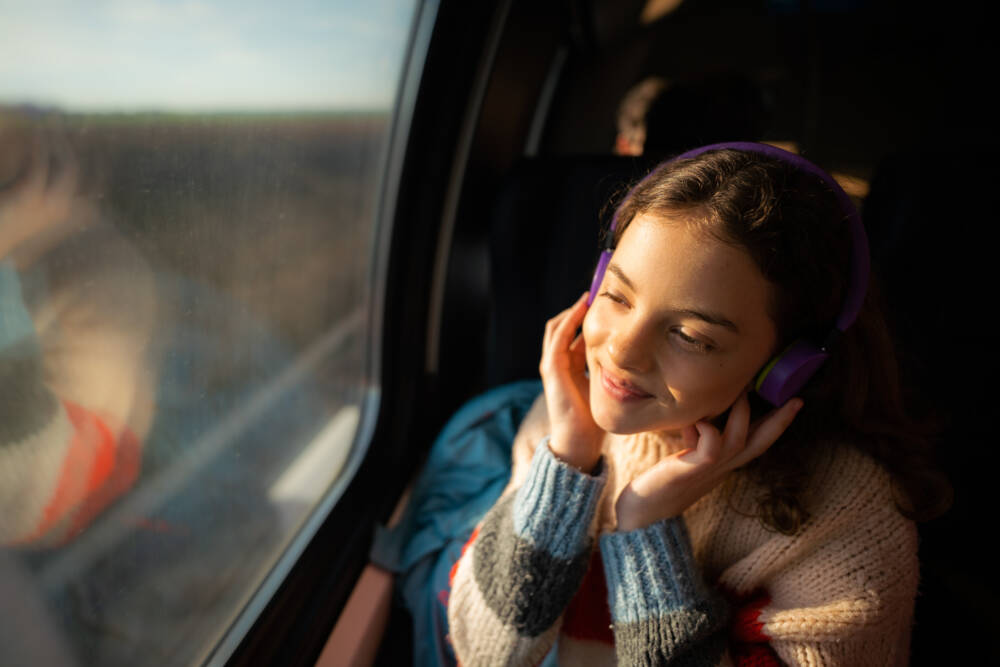 A woman uses headphones while traveling. (Getty Images)
