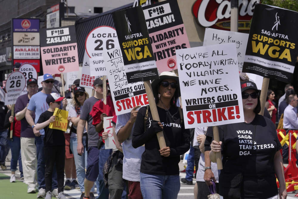 Protesters supporting the Hollywood writers' strike march in a picket line outside the entrance to Boston University's commencement on Sunday, May 21. (Steven Senne/AP)