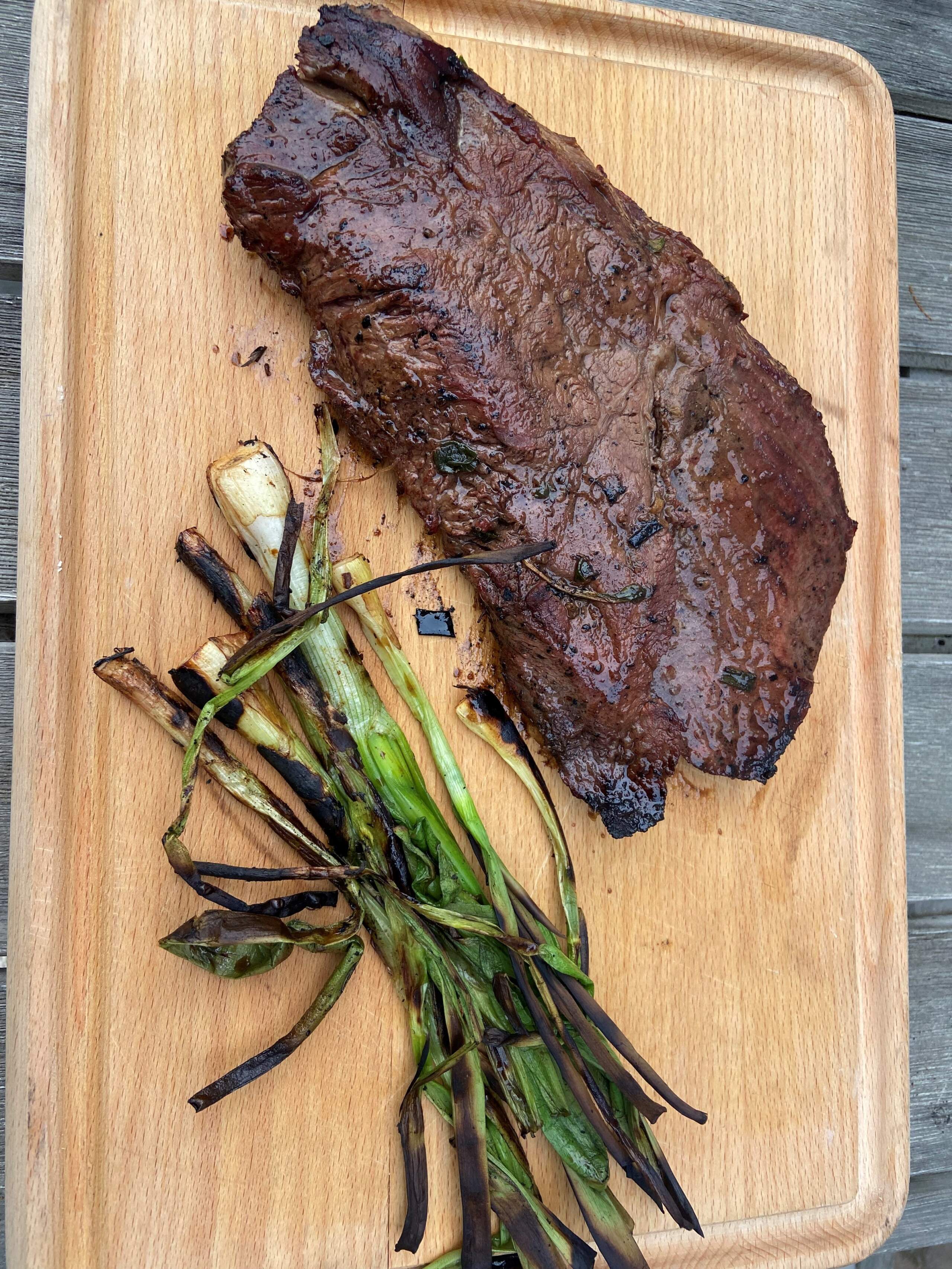 Grilled flat iron steak with soy-ginger marinade and grilled scallions. (Kathy Gunst/Here & Now)