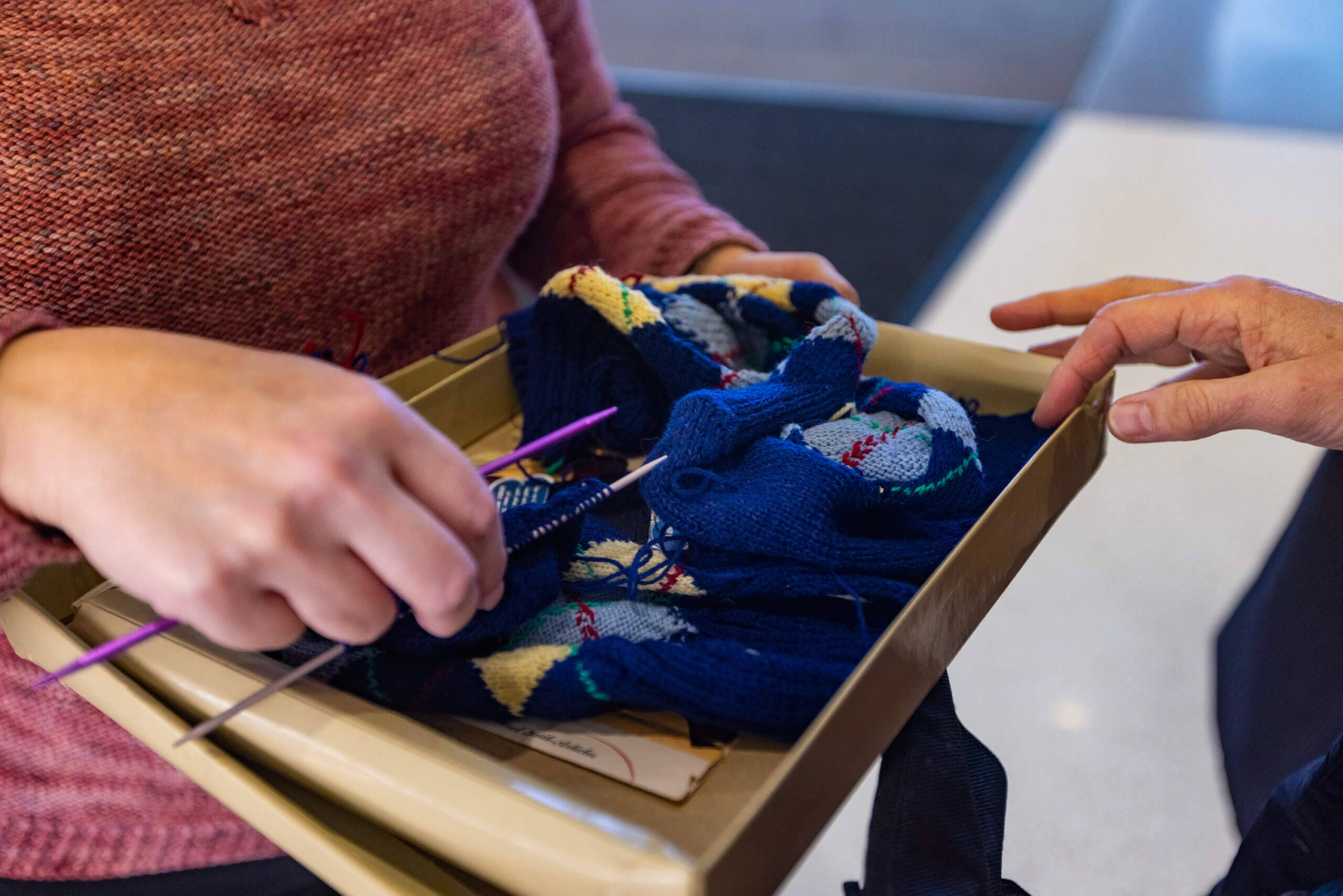 Mariah Lopshire volunteers to complete socks that Marcia Harris's mother started in 1948. (Jesse Costa/WBUR)