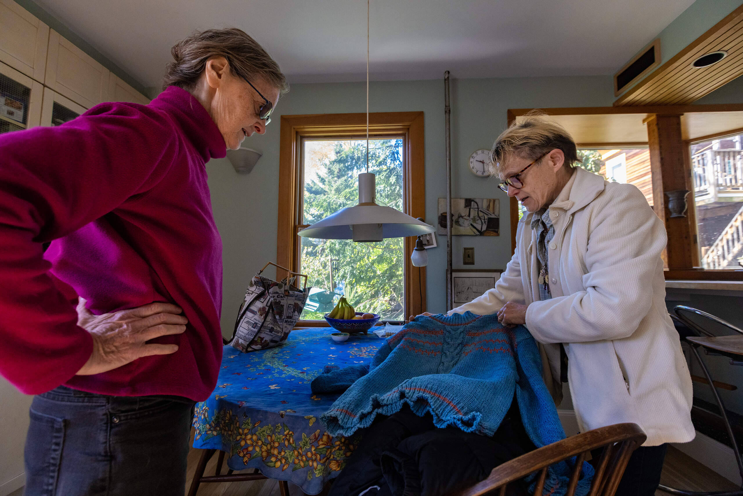 Diane Pullen picks up the sweater her late mother did not finish knitting before she passed away which Dawn Drevers completed. (Jesse Costa/WBUR)