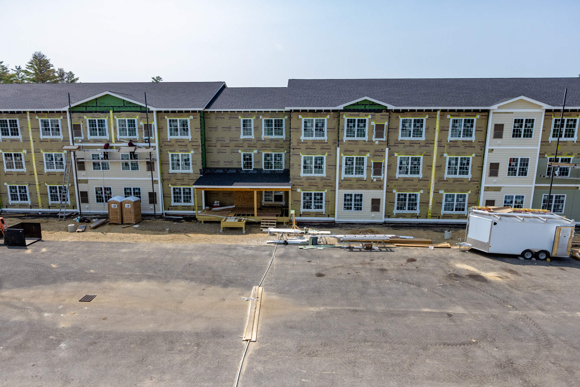 Contractors install siding onto one buildings of the West Swanzey Apartments manufactured housing project in Swanzey, NH. (Jesse Costa/WBUR)